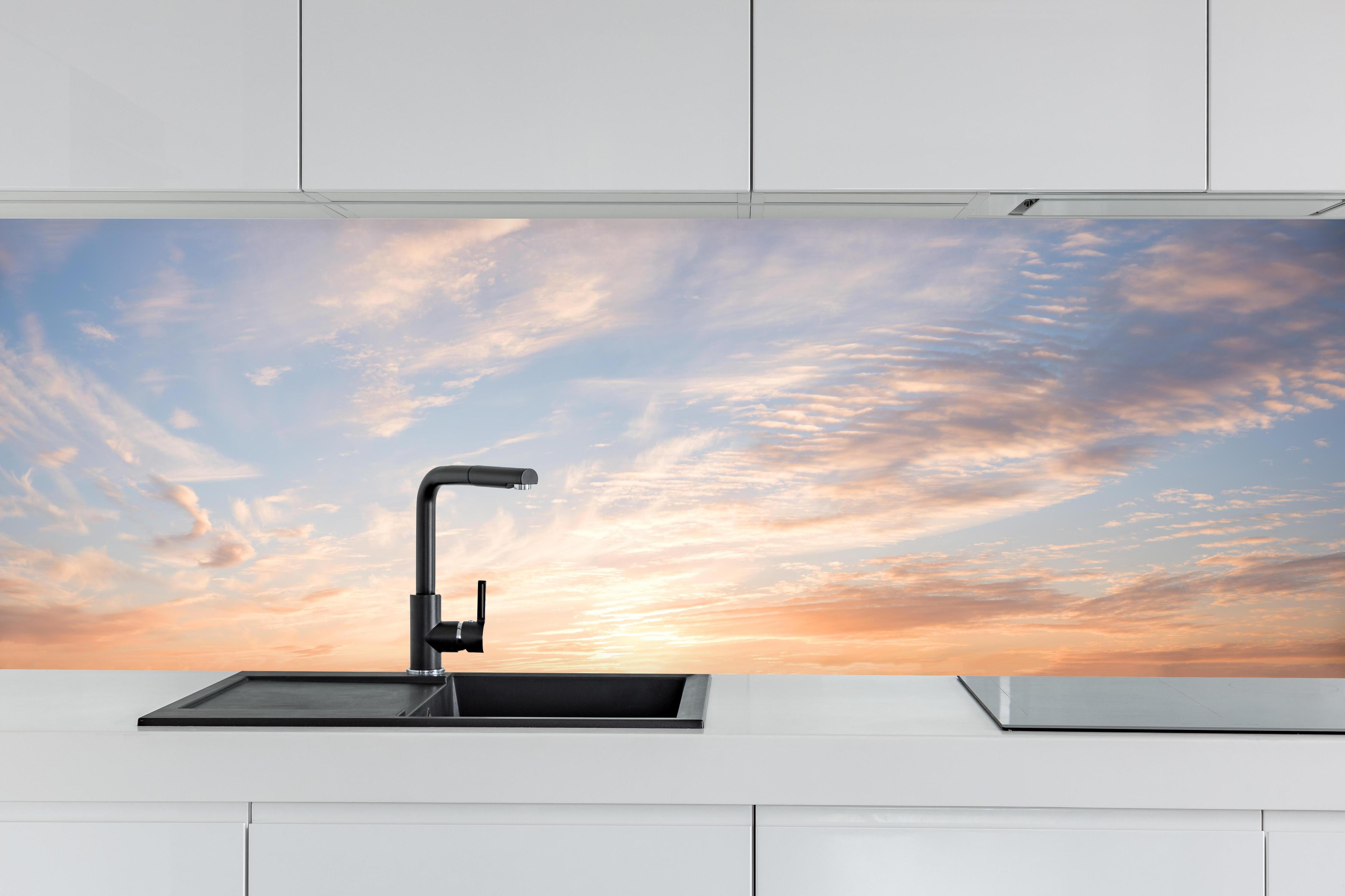 Küche - Pastellhimmel bei Sonnenuntergang hinter weißen Hochglanz-Küchenregalen und schwarzem Wasserhahn