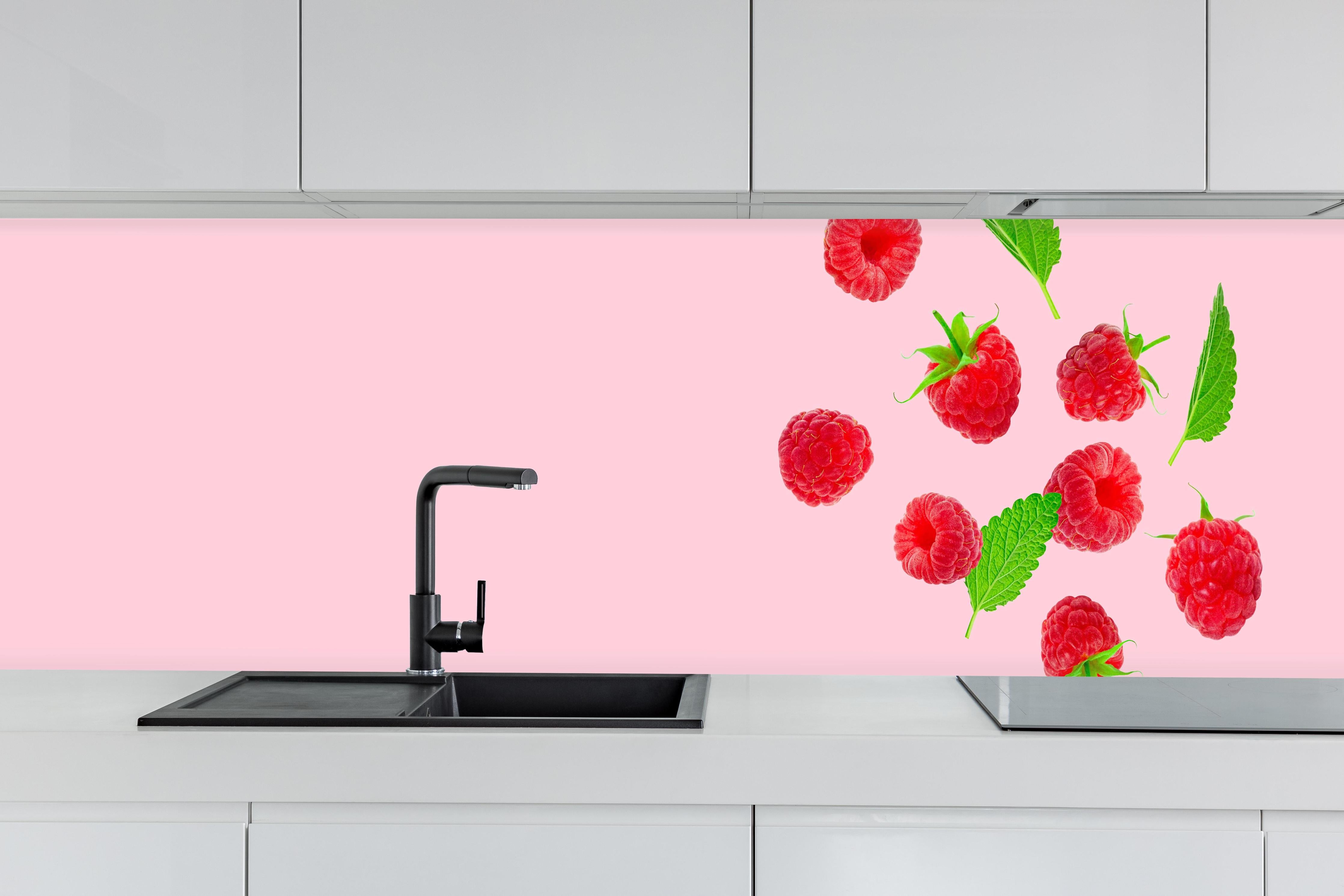Küche - Rosa Himbeeren mit Minze hinter weißen Hochglanz-Küchenregalen und schwarzem Wasserhahn