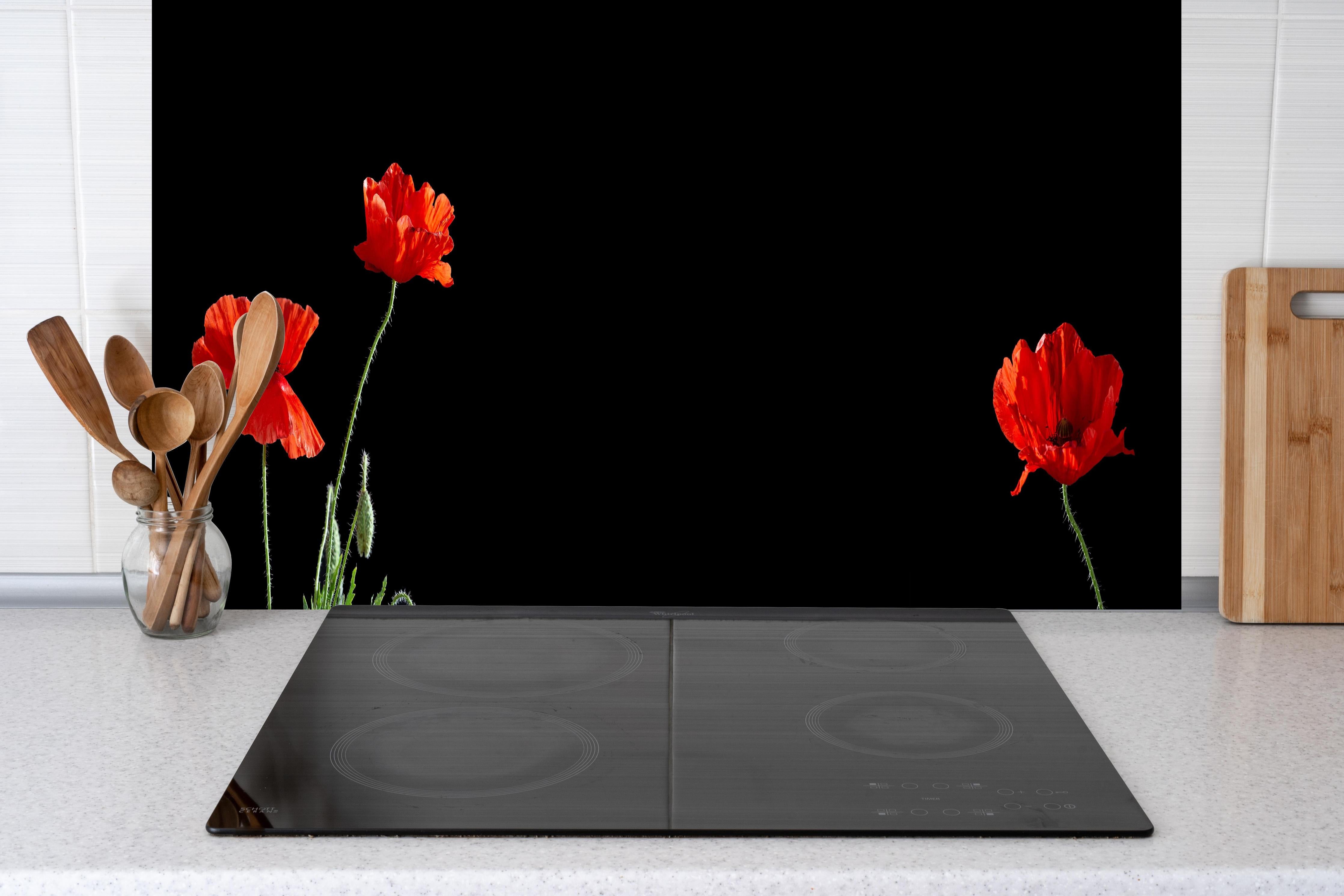 Küche - Rote Mohnblumen auf Schwarz hinter Cerankochfeld und Holz-Kochutensilien
