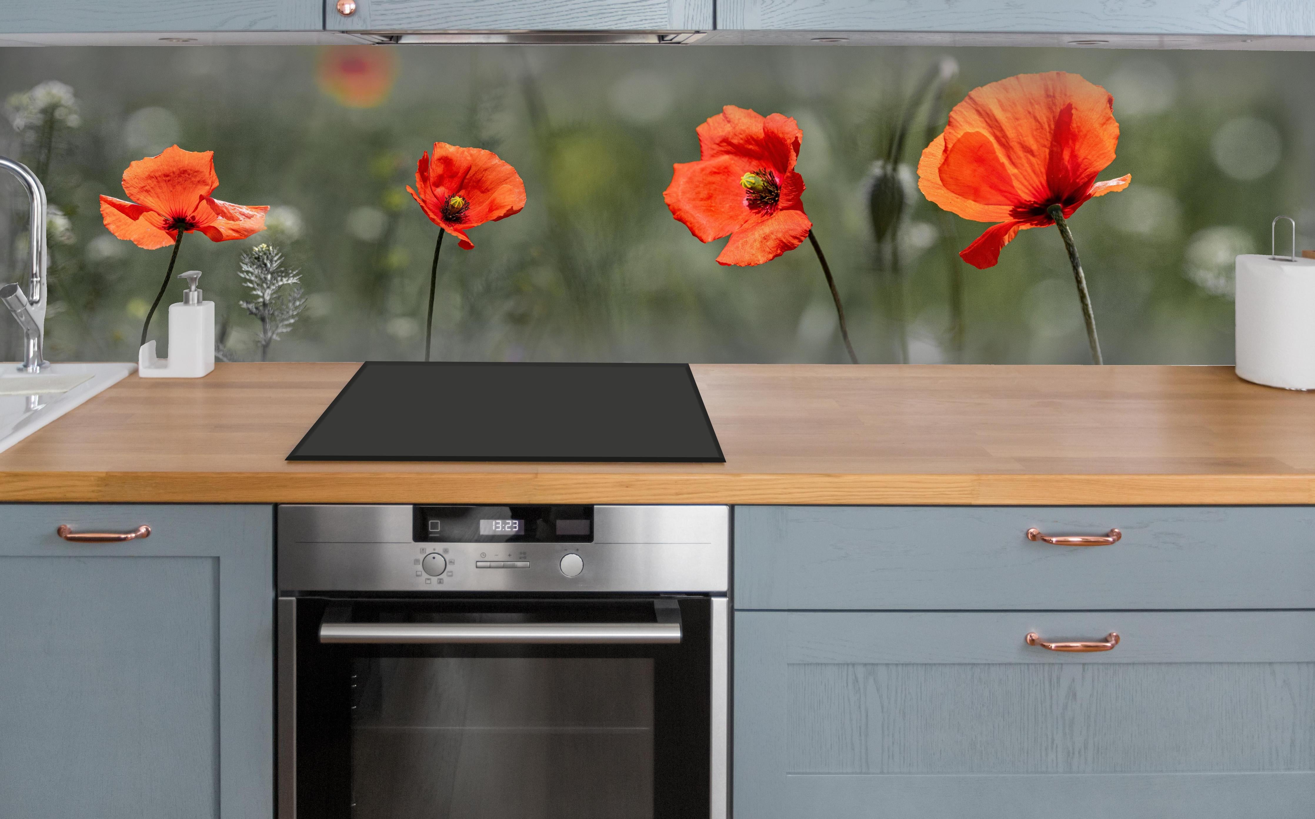 Küche - Roter Mohn inmitten des Grüns über polierter Holzarbeitsplatte mit Cerankochfeld