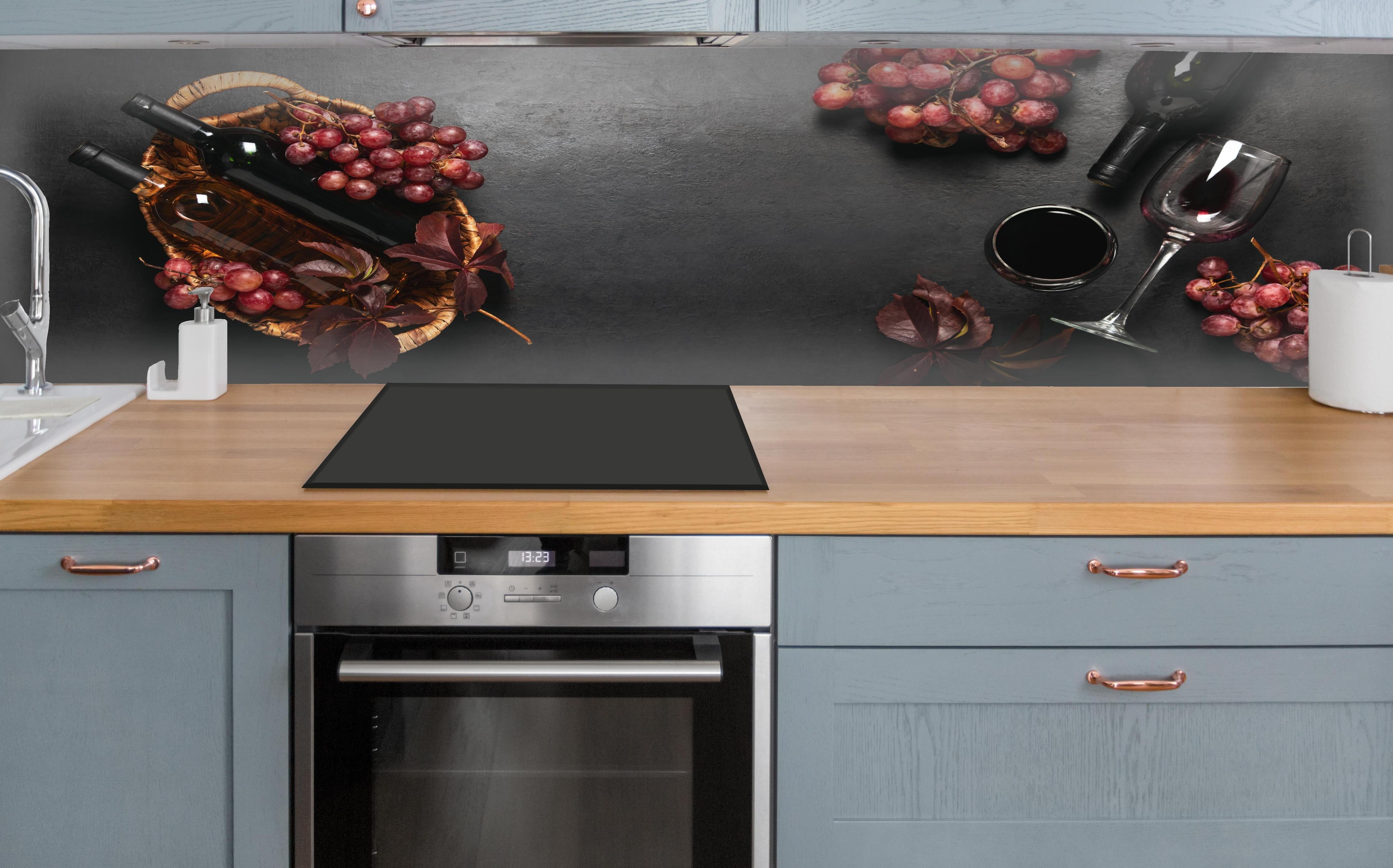 Küche - Rotwein-Stillleben auf Schwarz über polierter Holzarbeitsplatte mit Cerankochfeld
