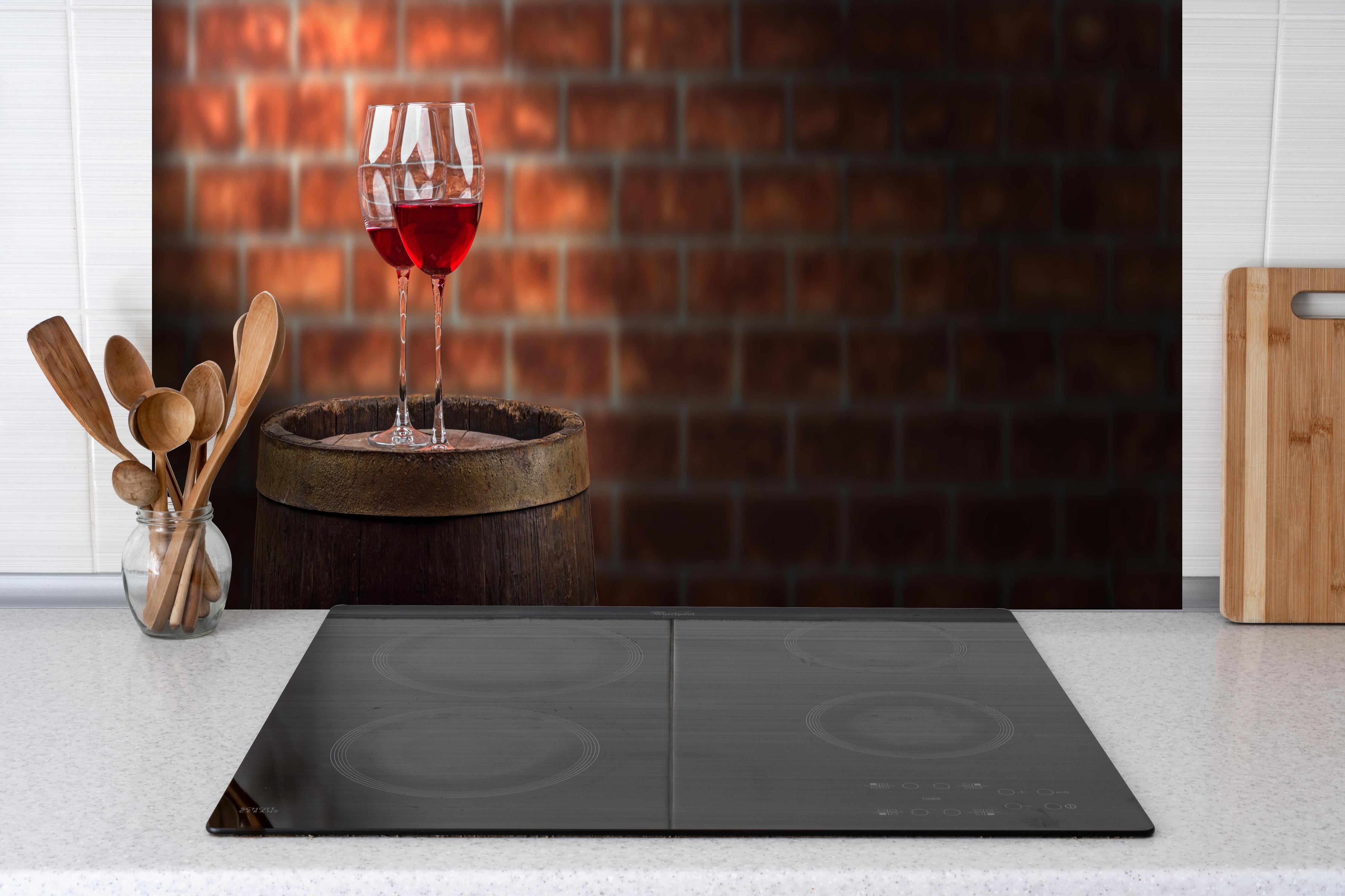 Küche - Rotwein auf Eichenfass hinter Cerankochfeld und Holz-Kochutensilien