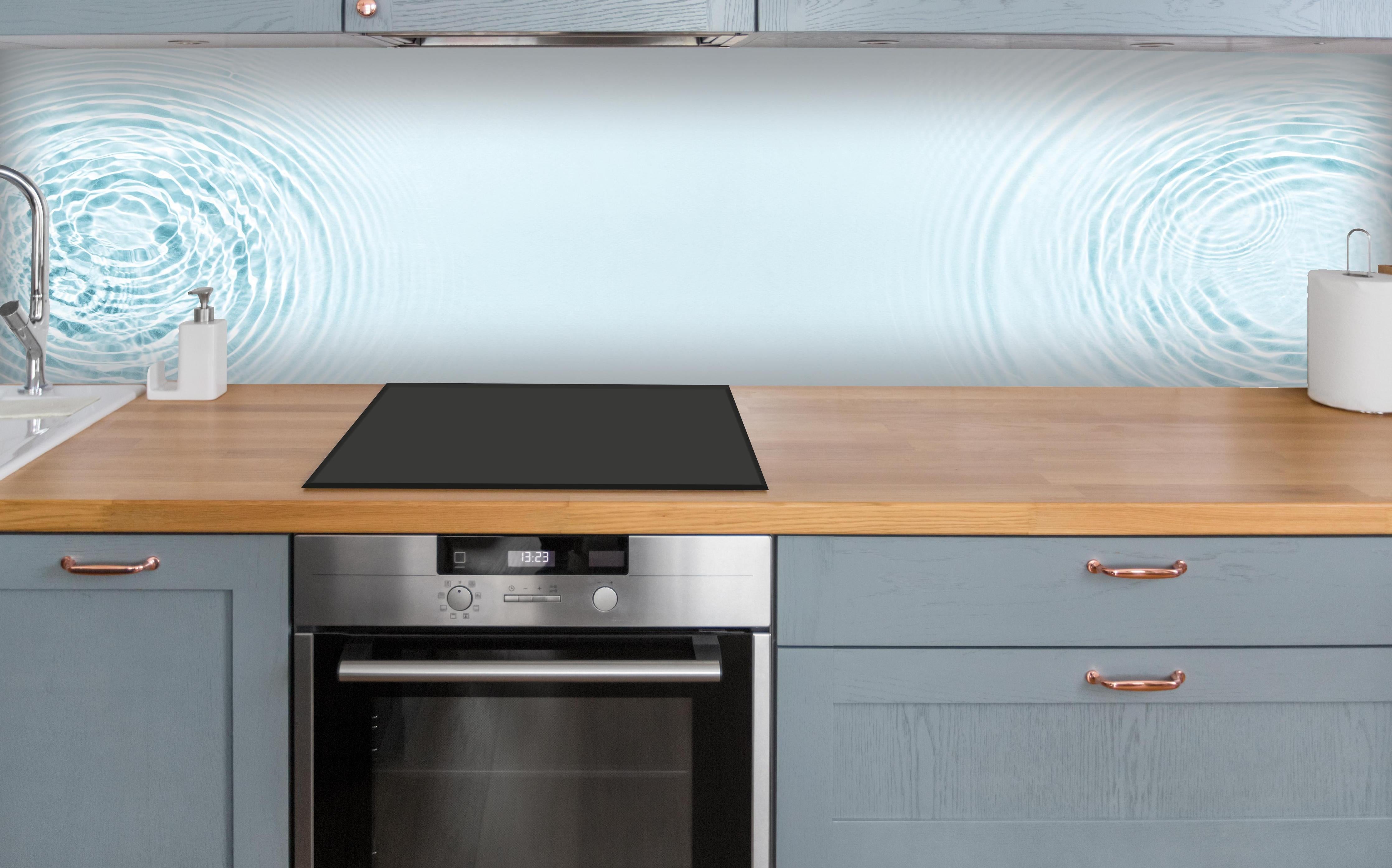 Küche - Sanfte blaue Wellenringe über polierter Holzarbeitsplatte mit Cerankochfeld