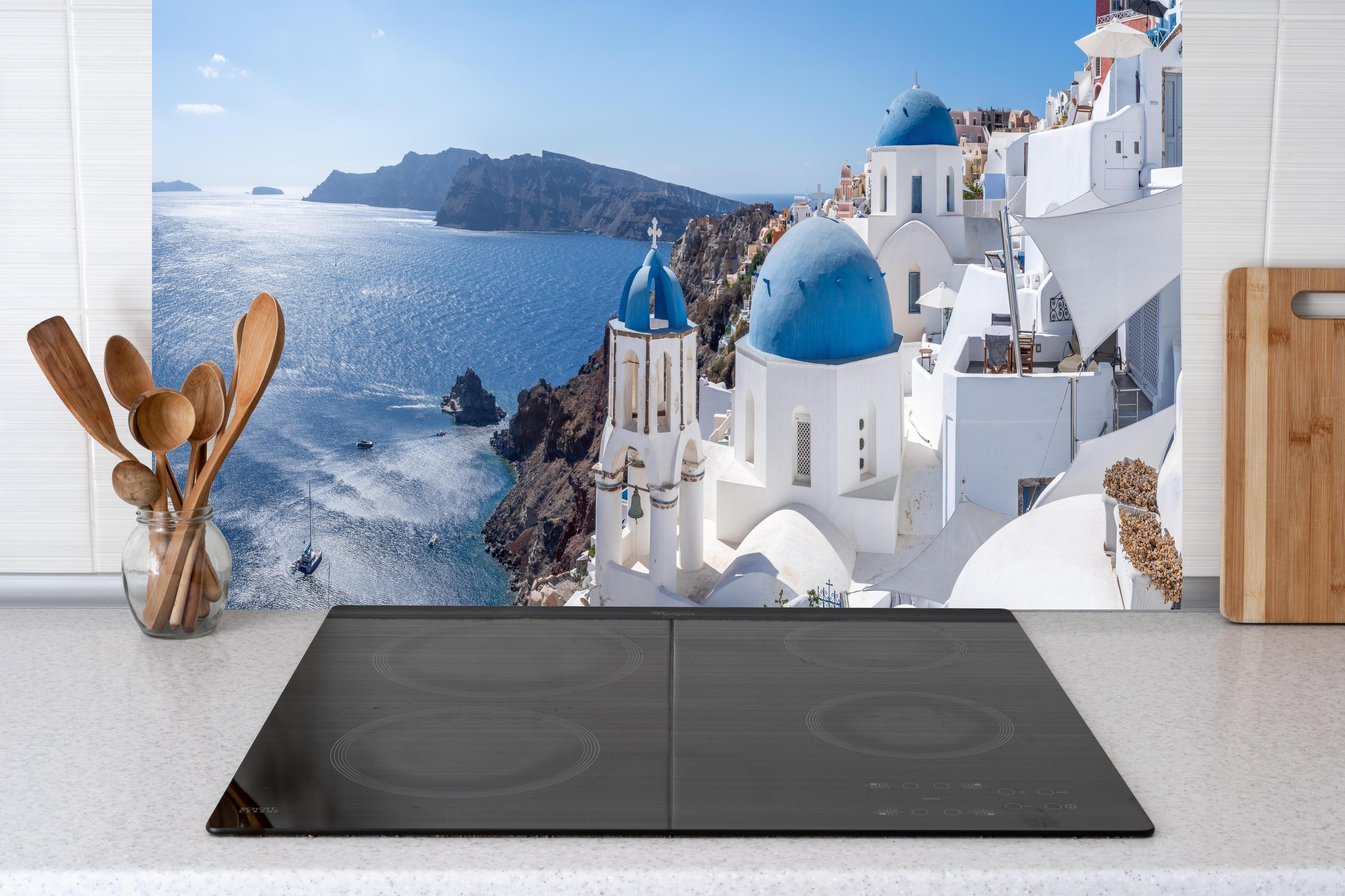 Küche - Santorini Blau-Weiß Skyline hinter Cerankochfeld und Holz-Kochutensilien