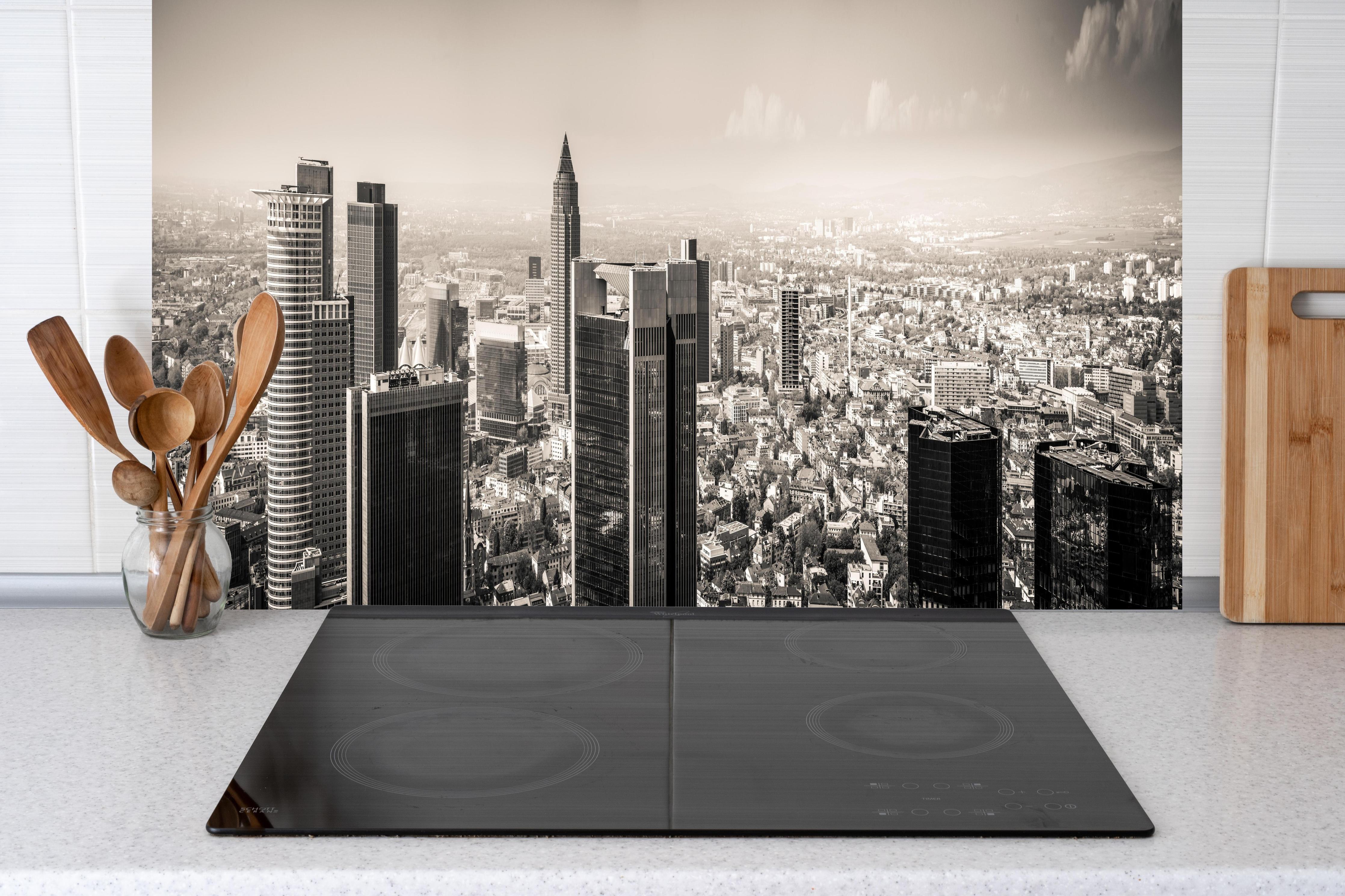Küche - Schwarz-Weiß Skyline Panorama hinter Cerankochfeld und Holz-Kochutensilien