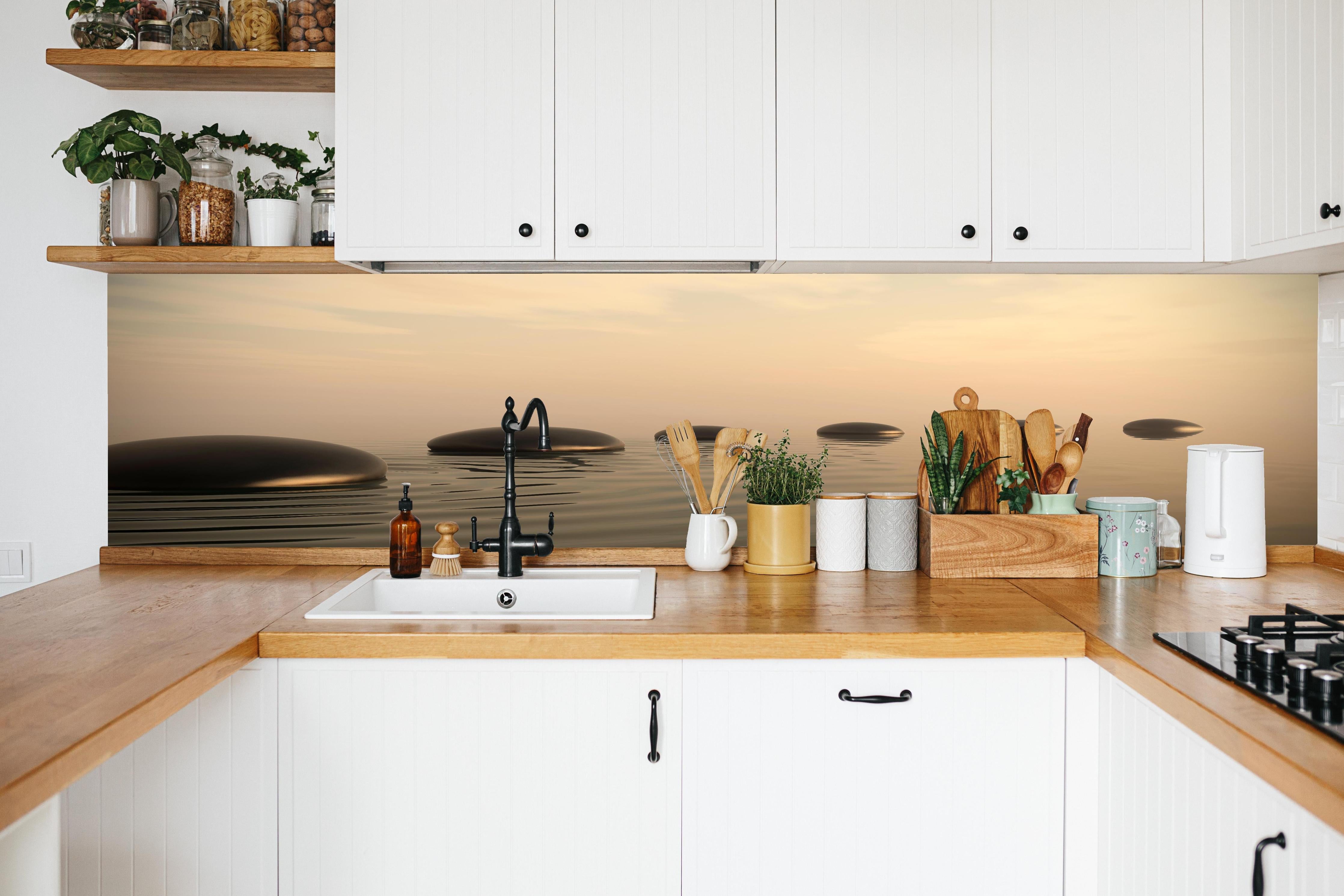 Küche - Schwarze Zen-Steine auf ruhigem Beige in weißer Küche hinter Gewürzen und Kochlöffeln aus Holz
