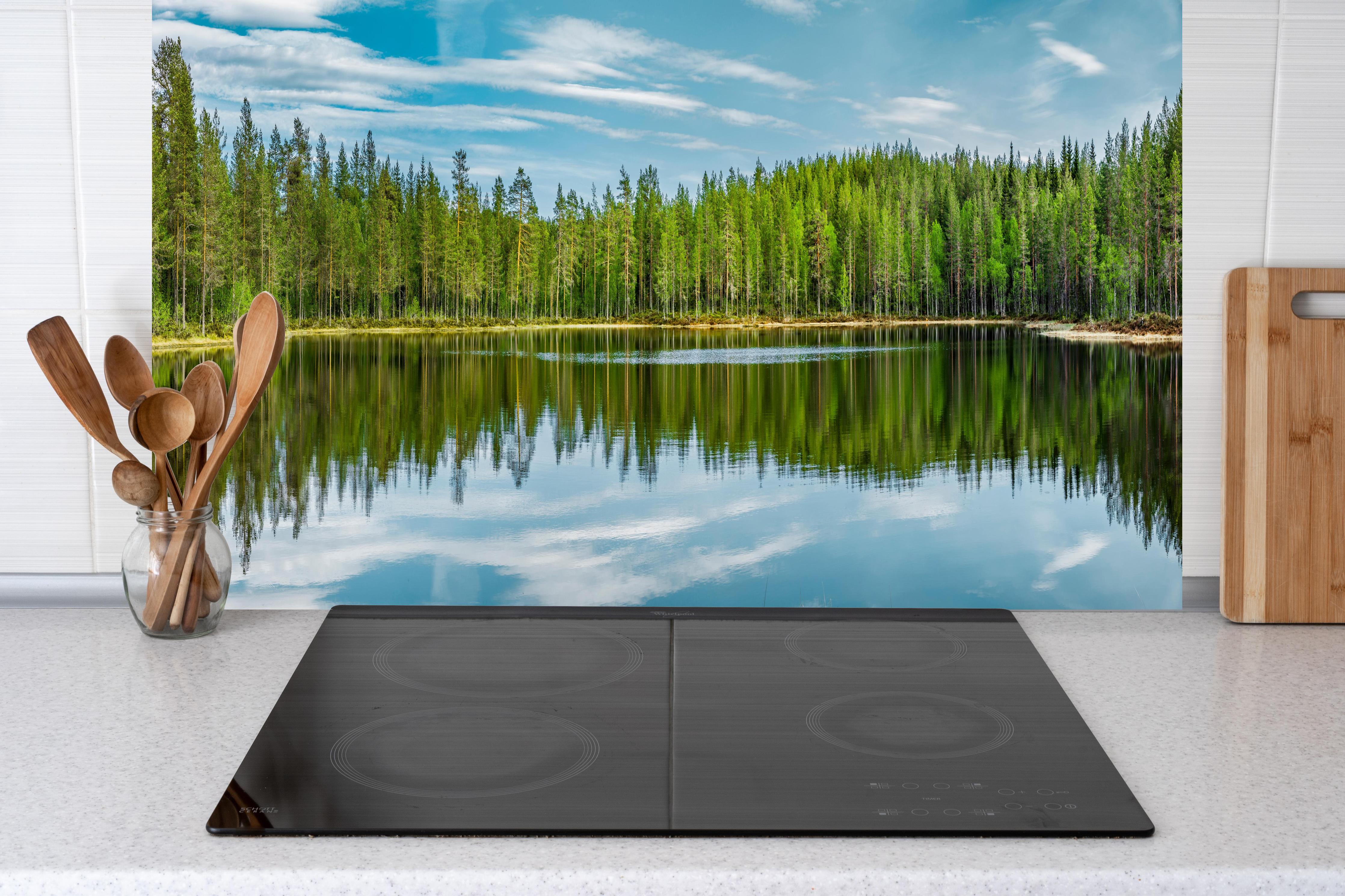 Küche - Schwedisches See-Panorama Grün-Blau hinter Cerankochfeld und Holz-Kochutensilien