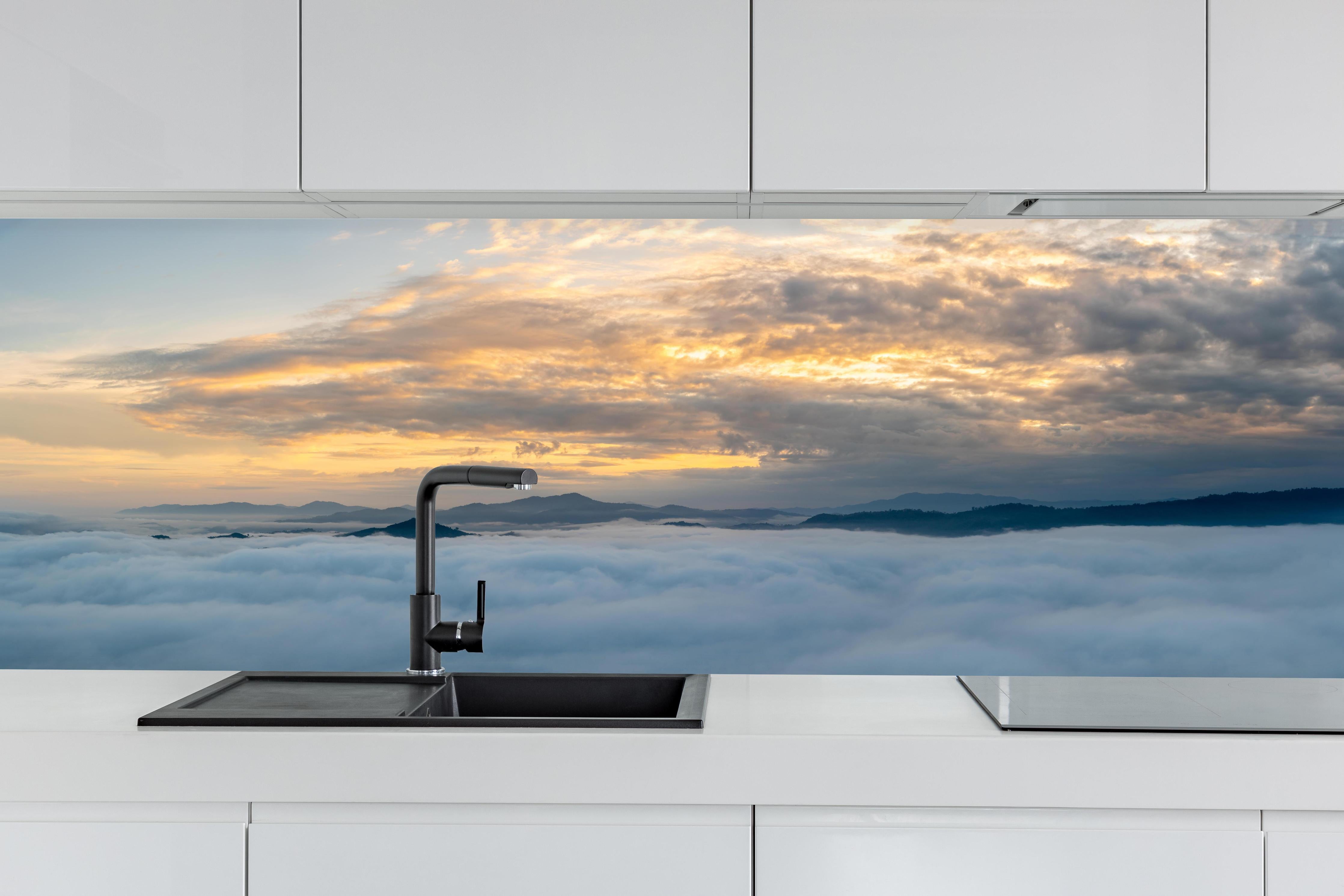 Küche - Sonnenuntergang über Wolkenmeer hinter weißen Hochglanz-Küchenregalen und schwarzem Wasserhahn