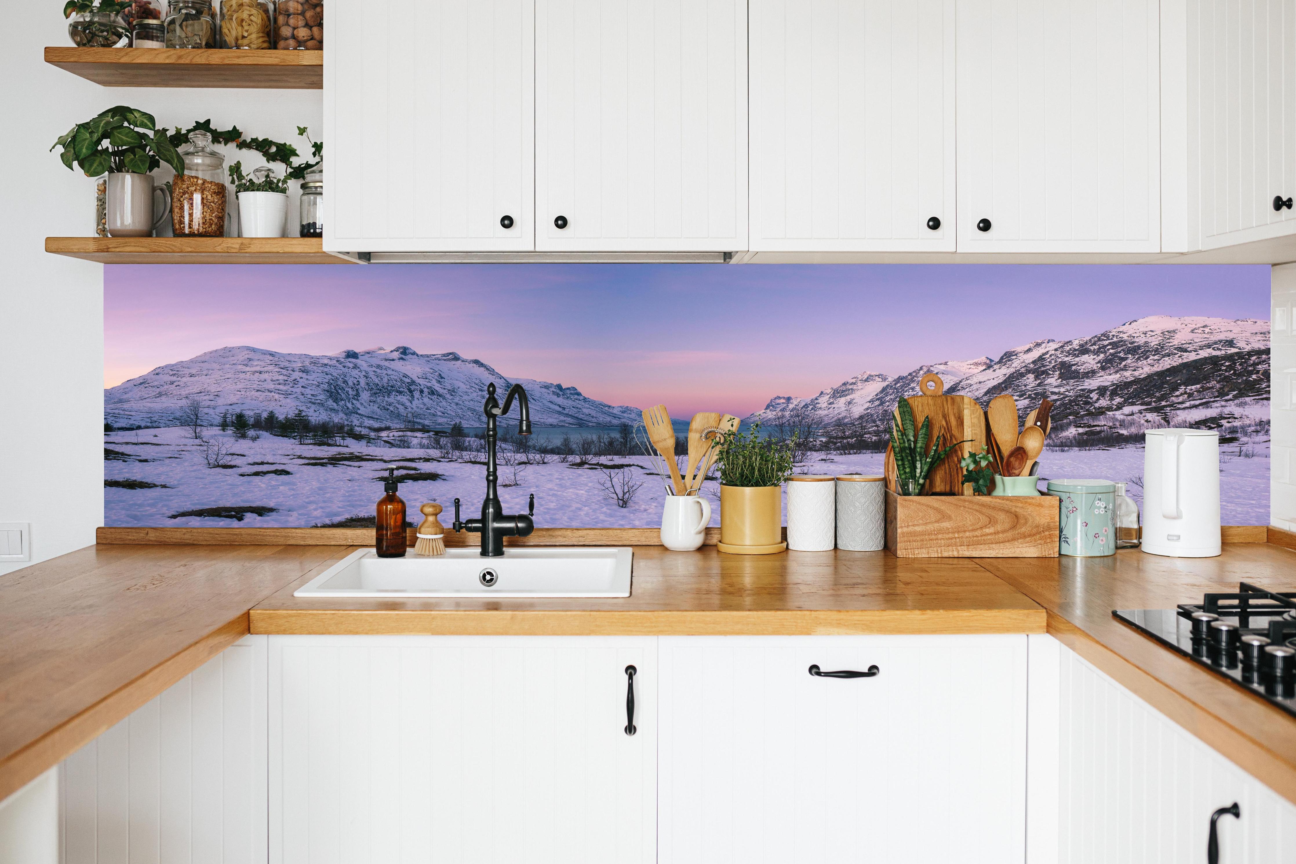 Küche - Sonnenuntergang über verschneiten Bergen in weißer Küche hinter Gewürzen und Kochlöffeln aus Holz