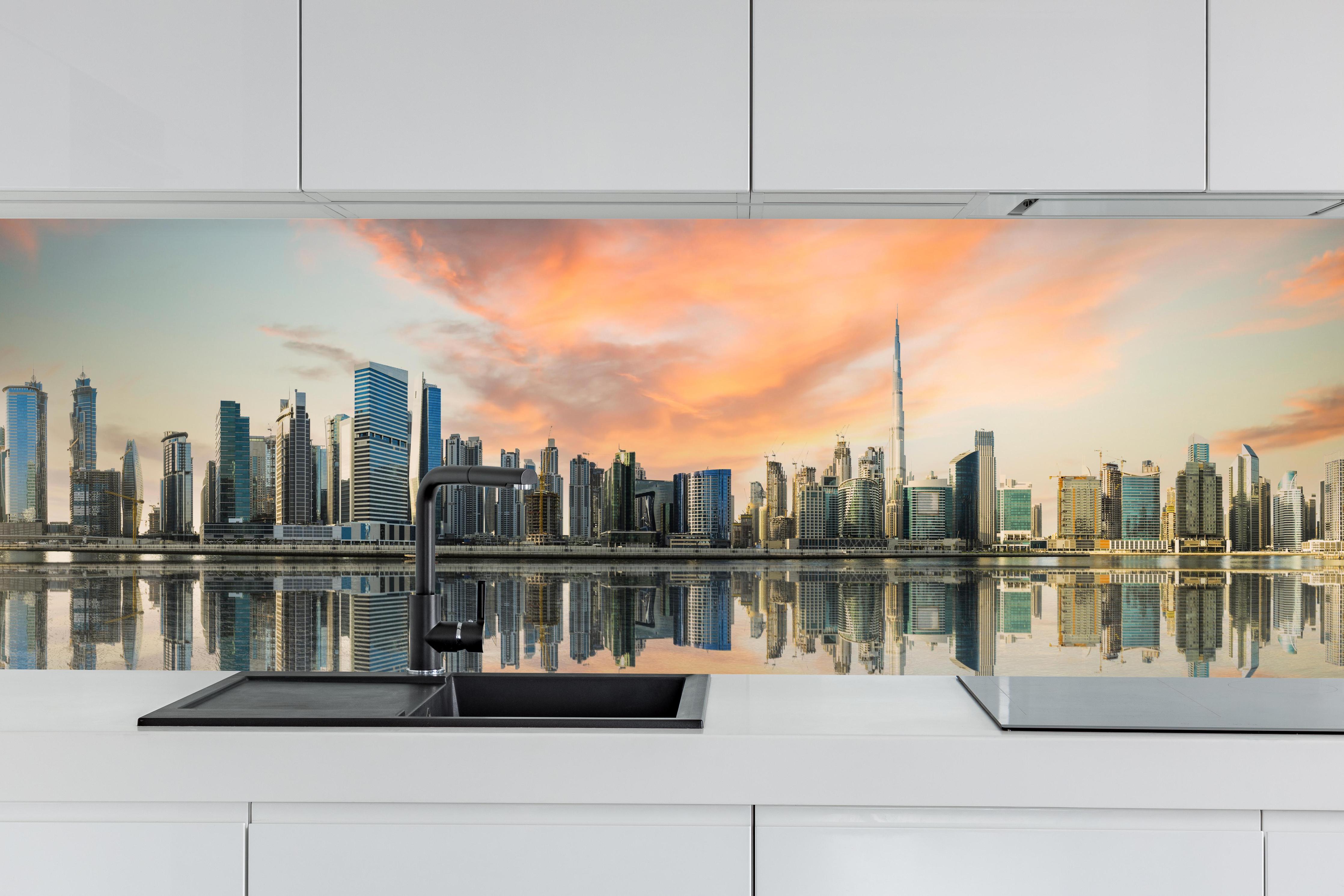 Küche - Stadt-Skyline im Abendrot hinter weißen Hochglanz-Küchenregalen und schwarzem Wasserhahn