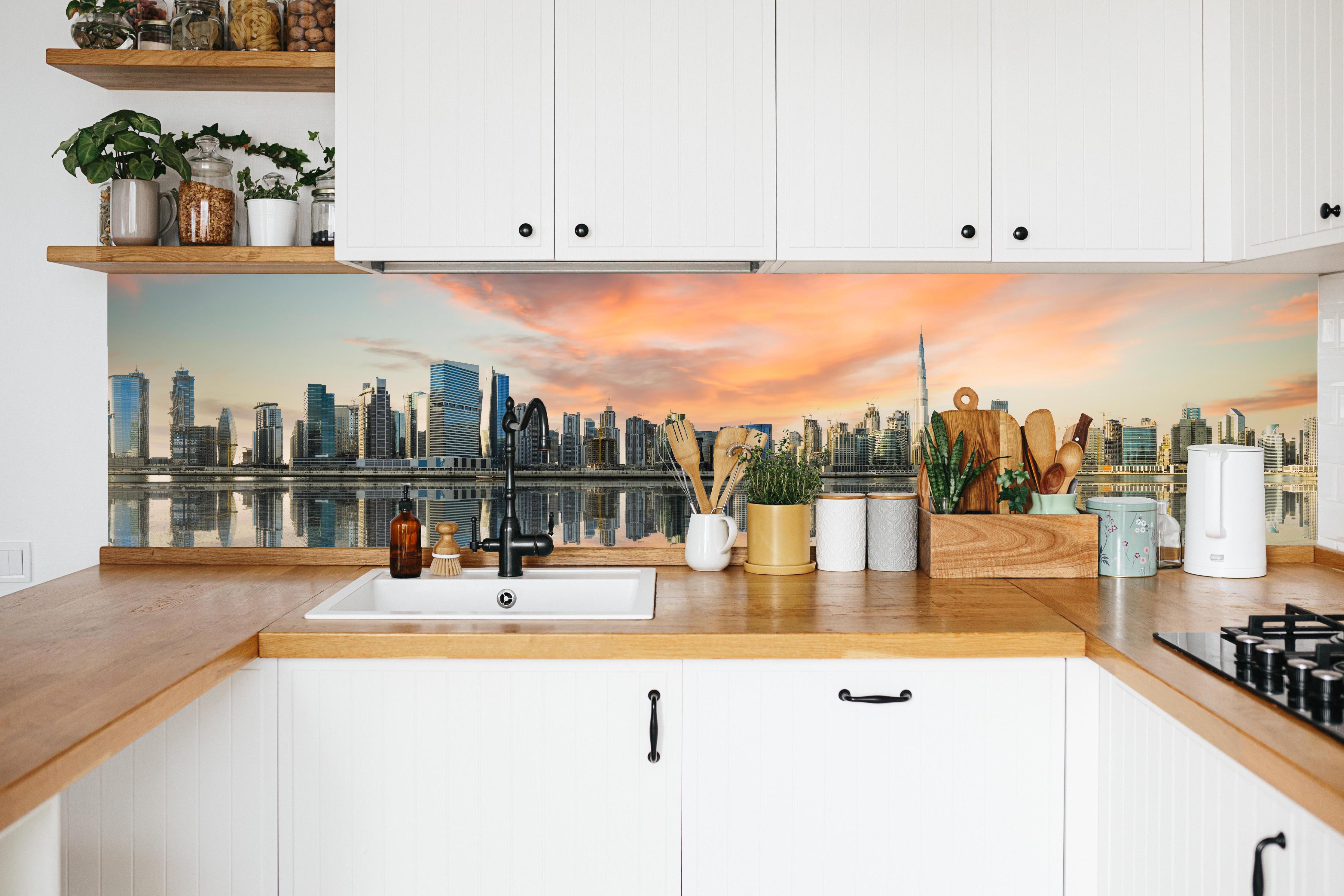 Küche - Stadt-Skyline im Abendrot in weißer Küche hinter Gewürzen und Kochlöffeln aus Holz