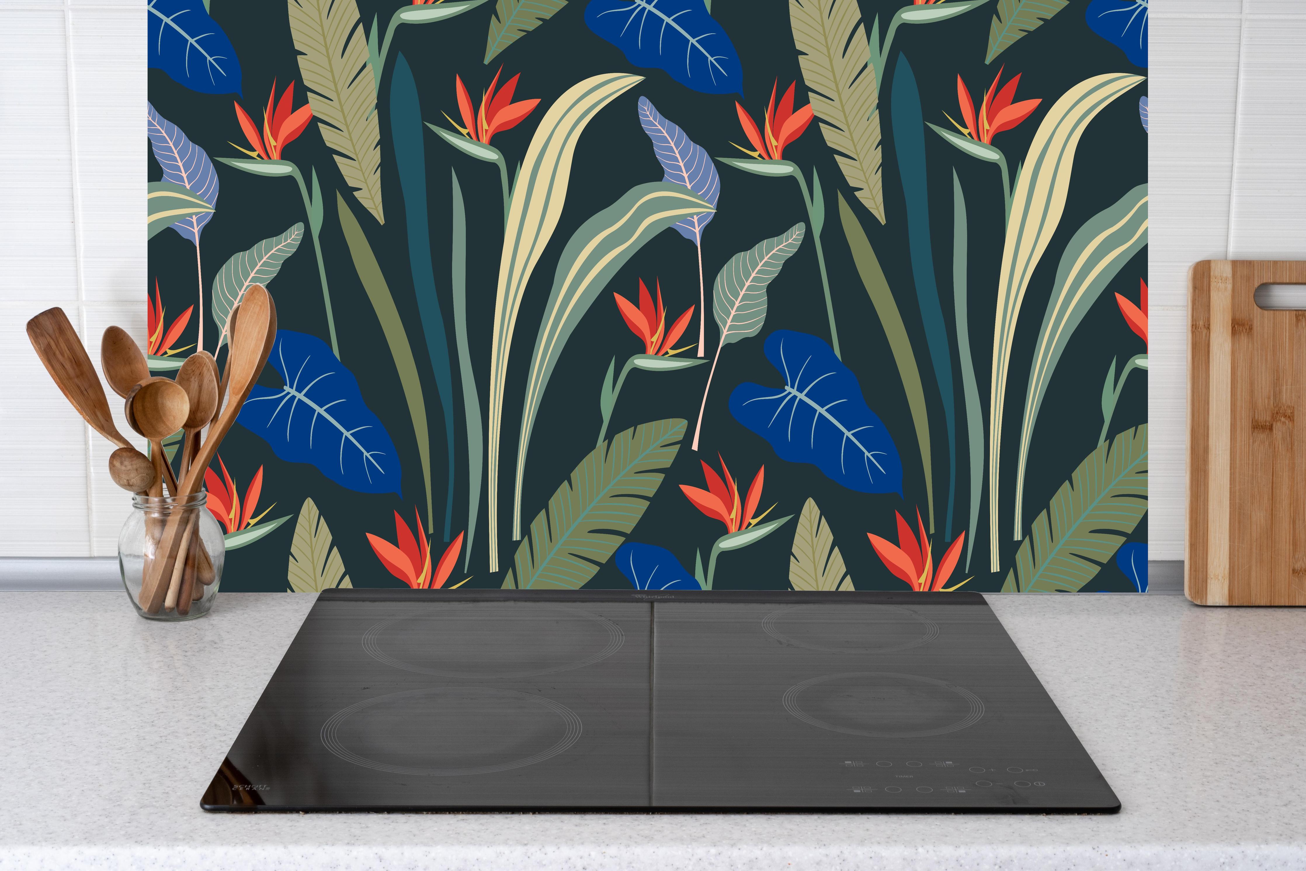 Küche - Strelitzia Tropische Blütenpracht hinter Cerankochfeld und Holz-Kochutensilien