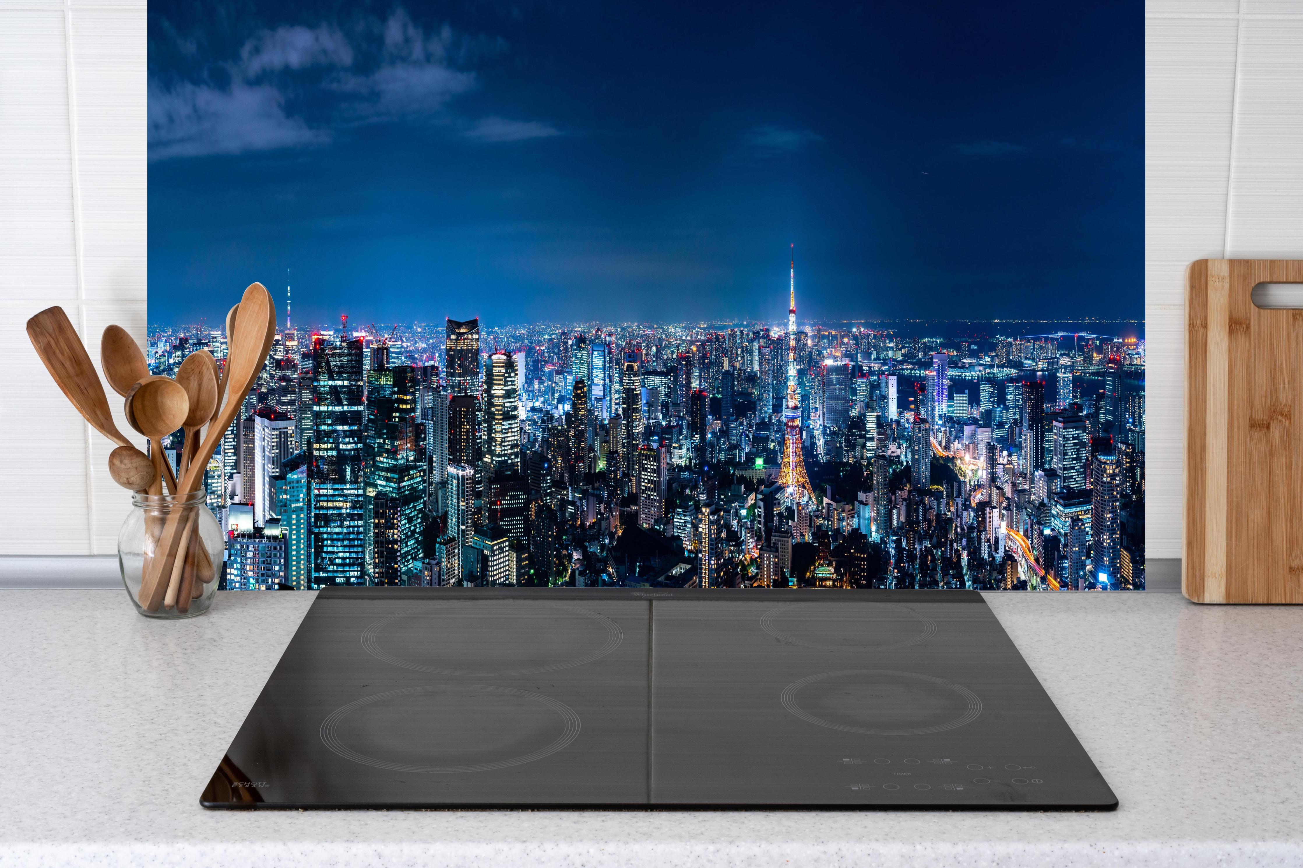 Küche - Tokio Skyline bei Nacht hinter Cerankochfeld und Holz-Kochutensilien