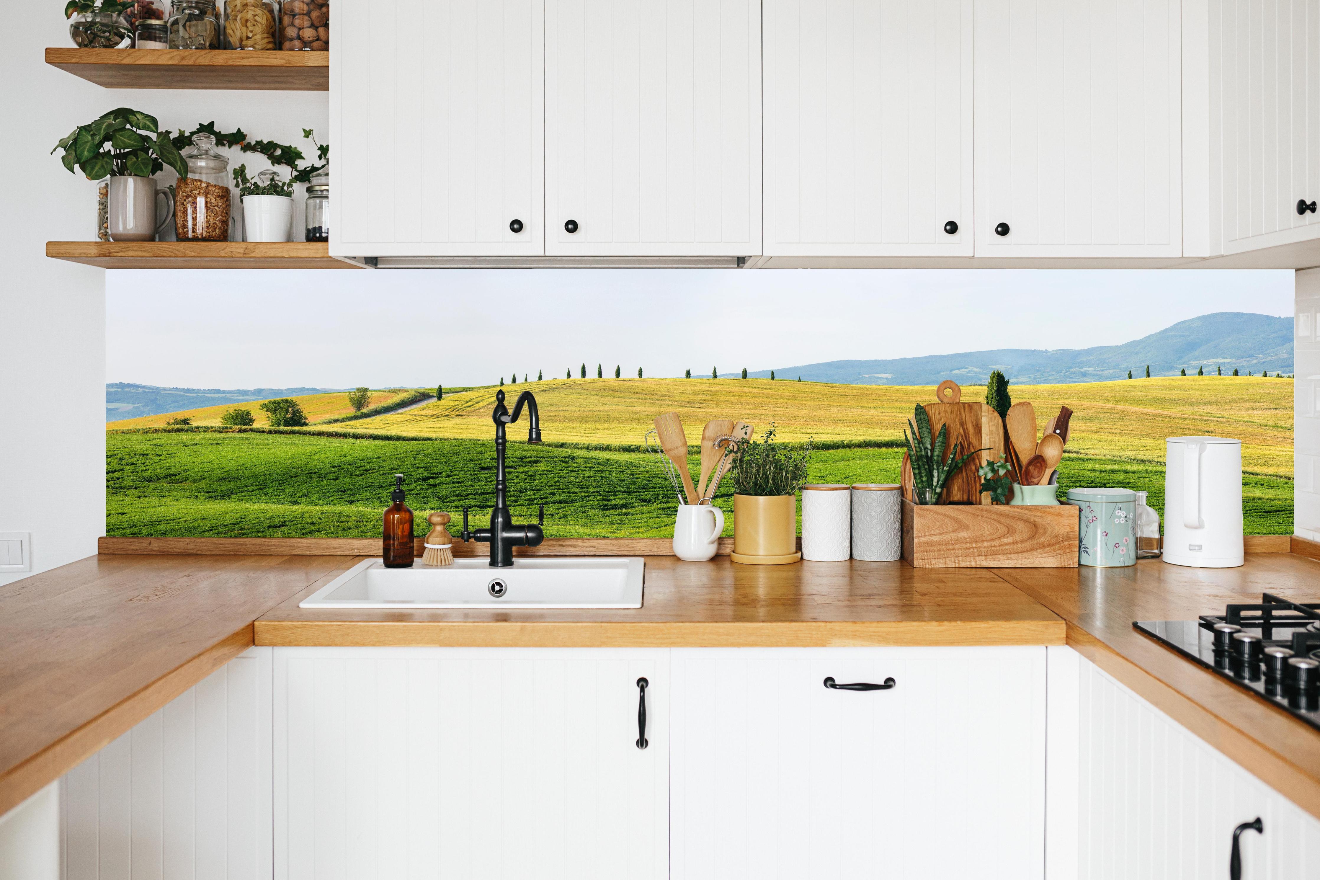 Küche - Toskana Hügel Panorama Grün-Gelb in weißer Küche hinter Gewürzen und Kochlöffeln aus Holz