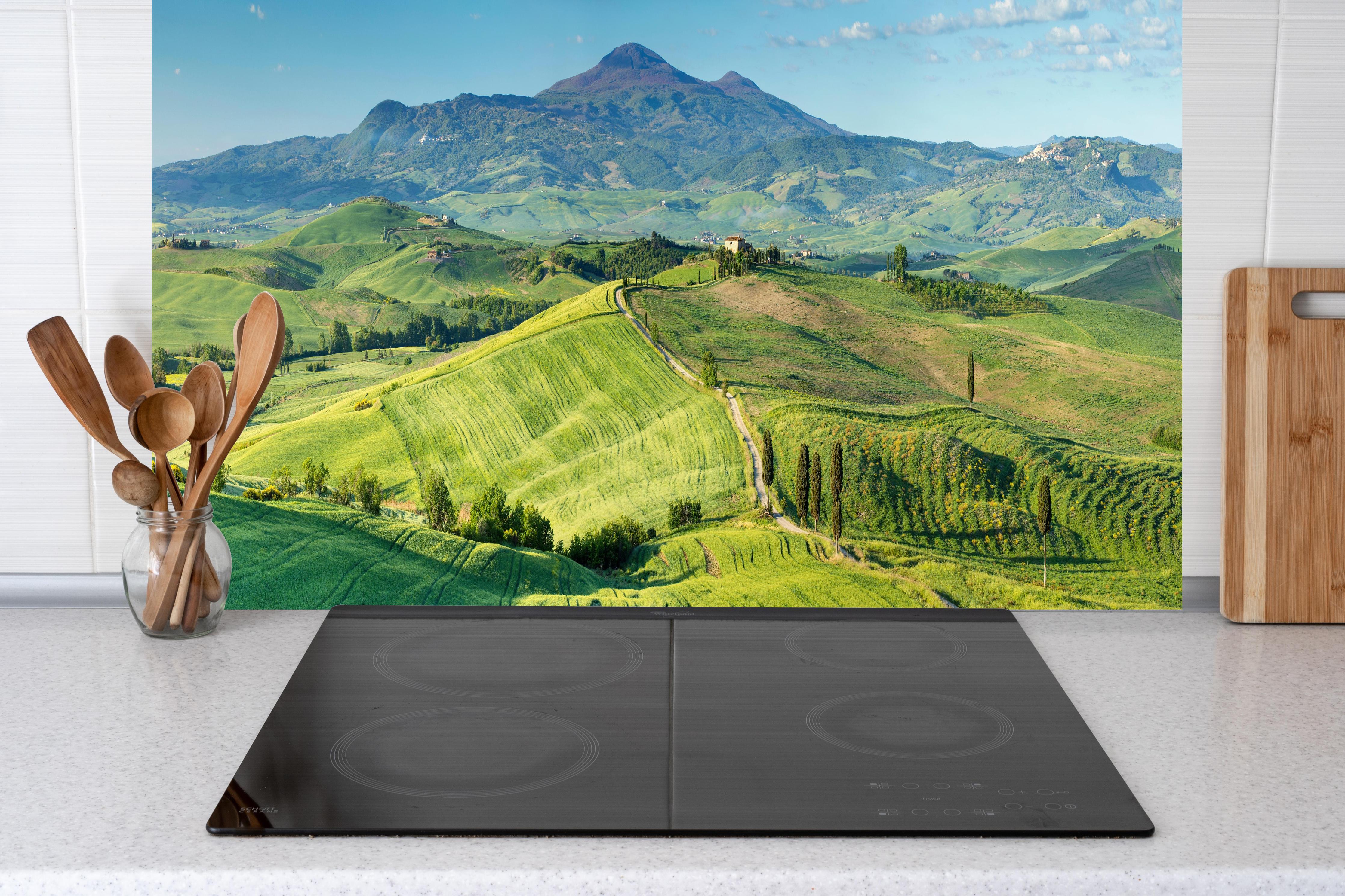 Küche - Toskana Hügel Panorama hinter Cerankochfeld und Holz-Kochutensilien