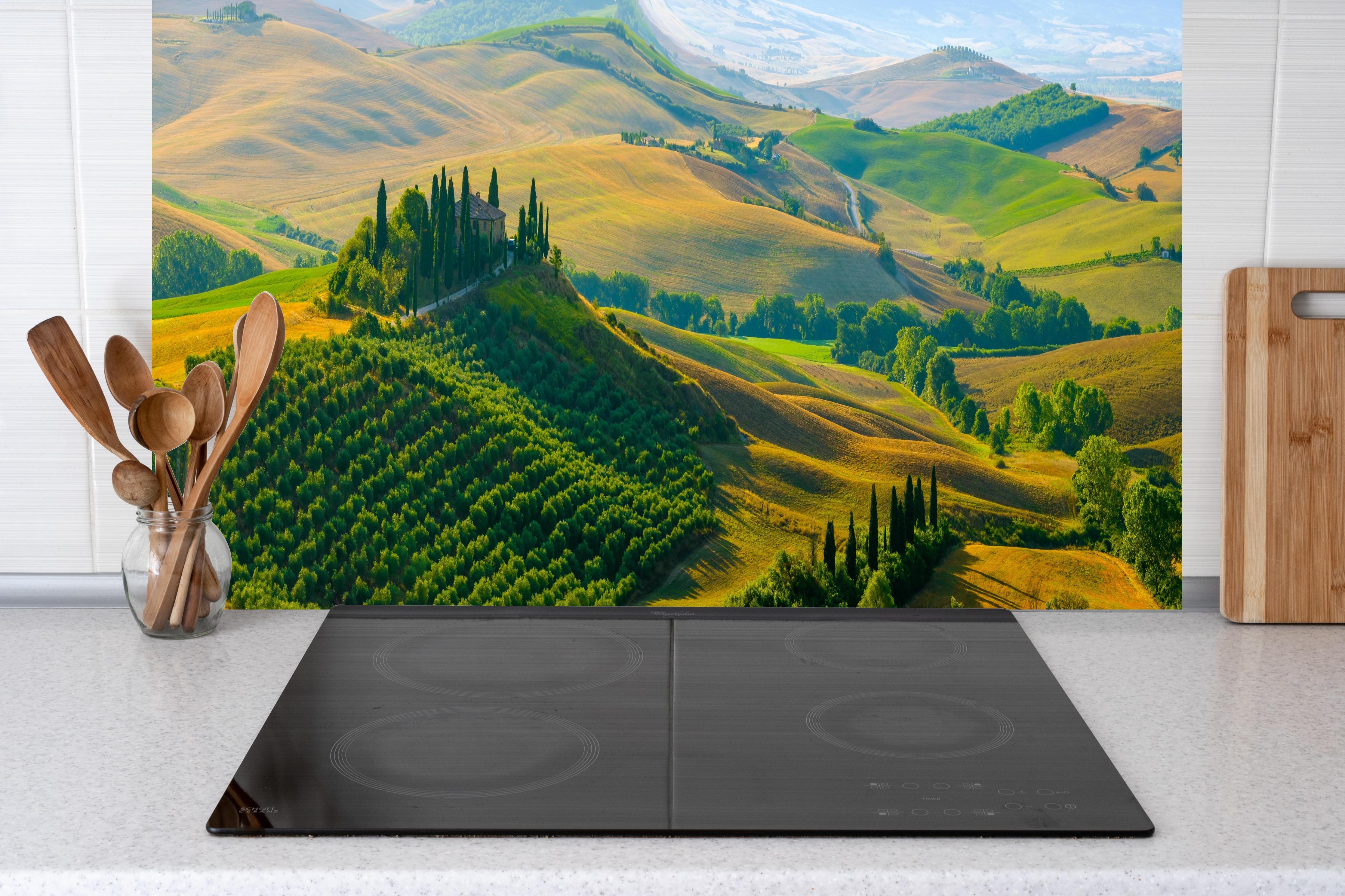 Küche - Toskana Hügel in Grün hinter Cerankochfeld und Holz-Kochutensilien