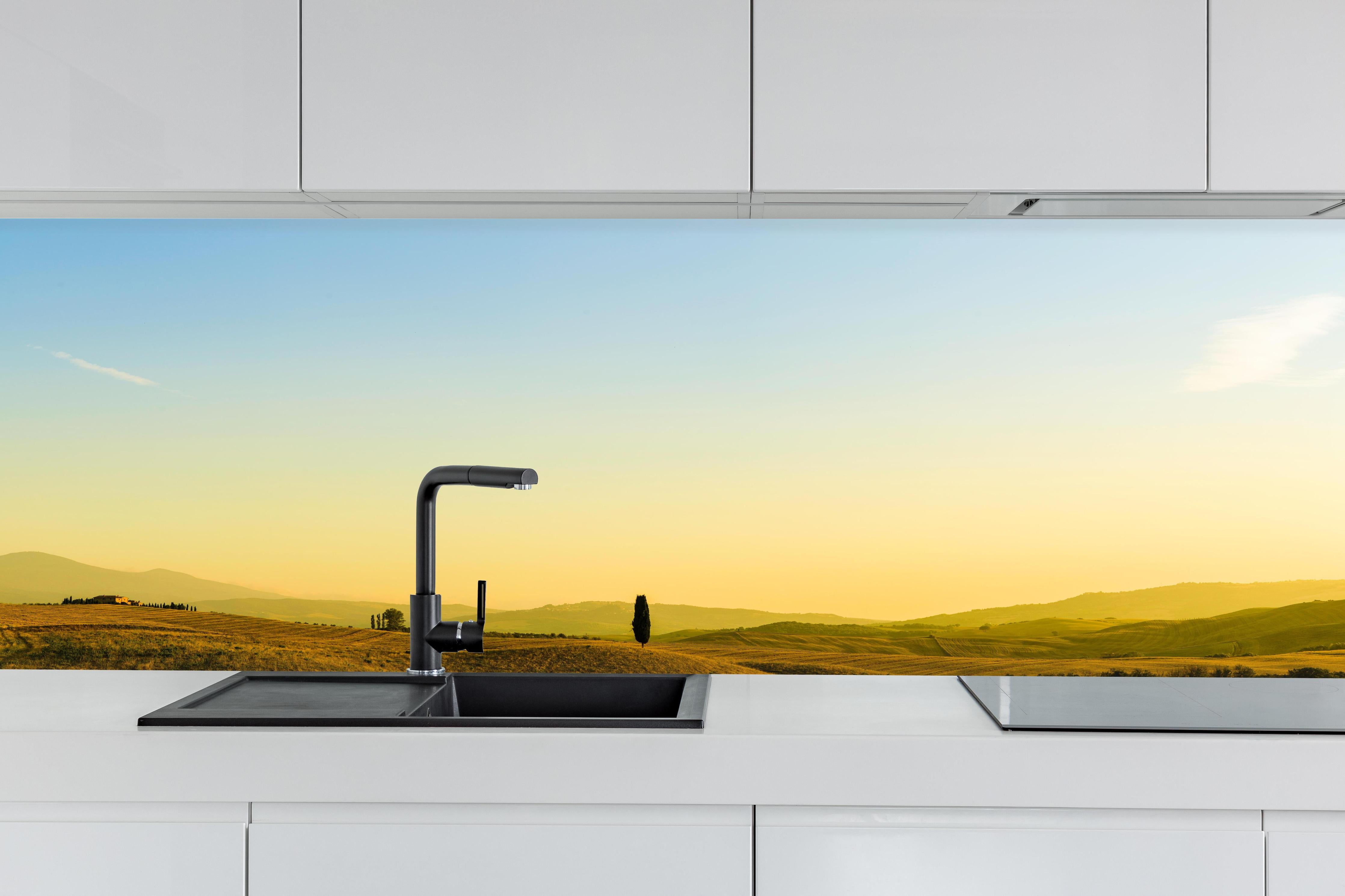 Küche - Toskanische Hügel im Abendlicht hinter weißen Hochglanz-Küchenregalen und schwarzem Wasserhahn