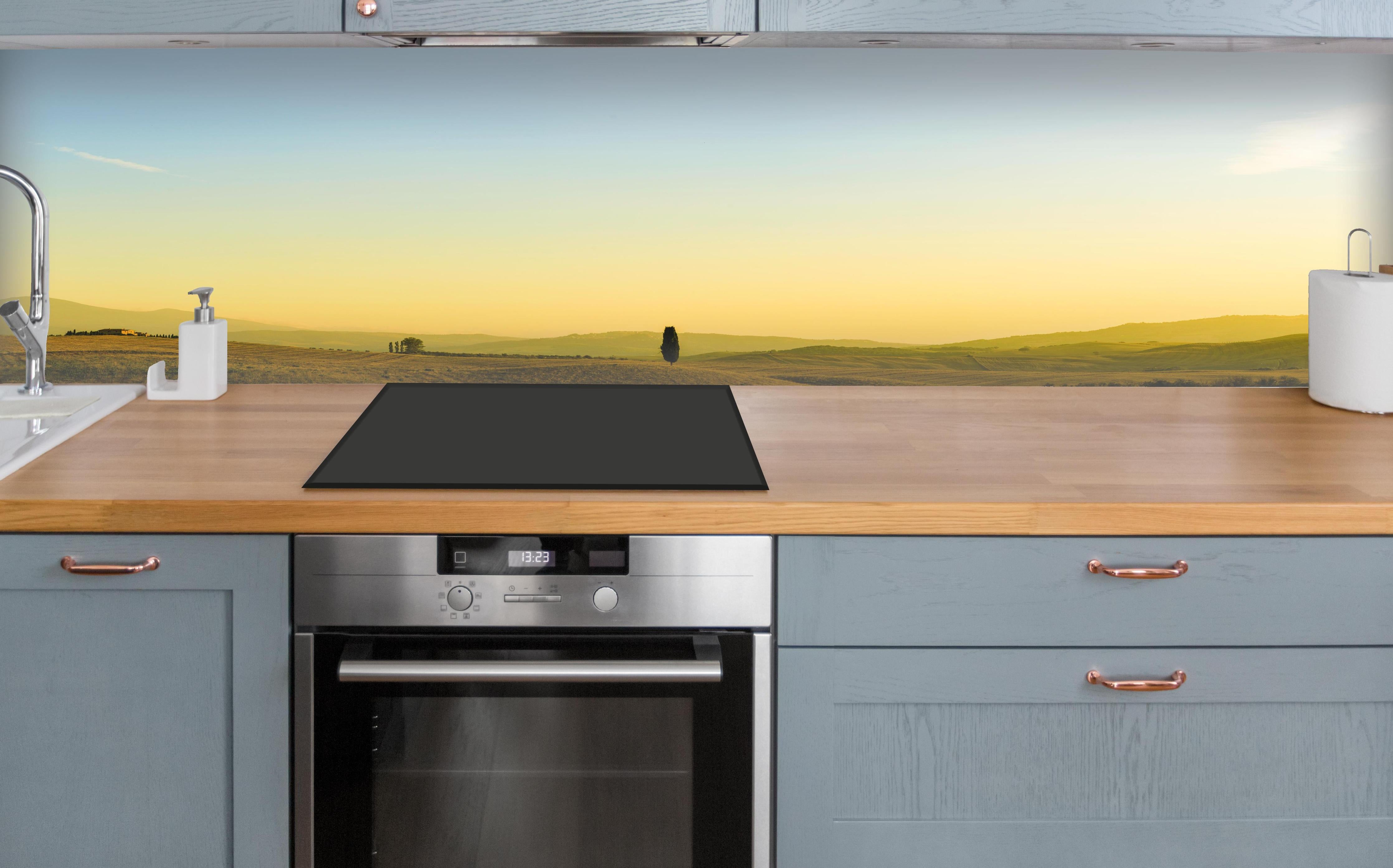 Küche - Toskanische Hügel im Abendlicht über polierter Holzarbeitsplatte mit Cerankochfeld