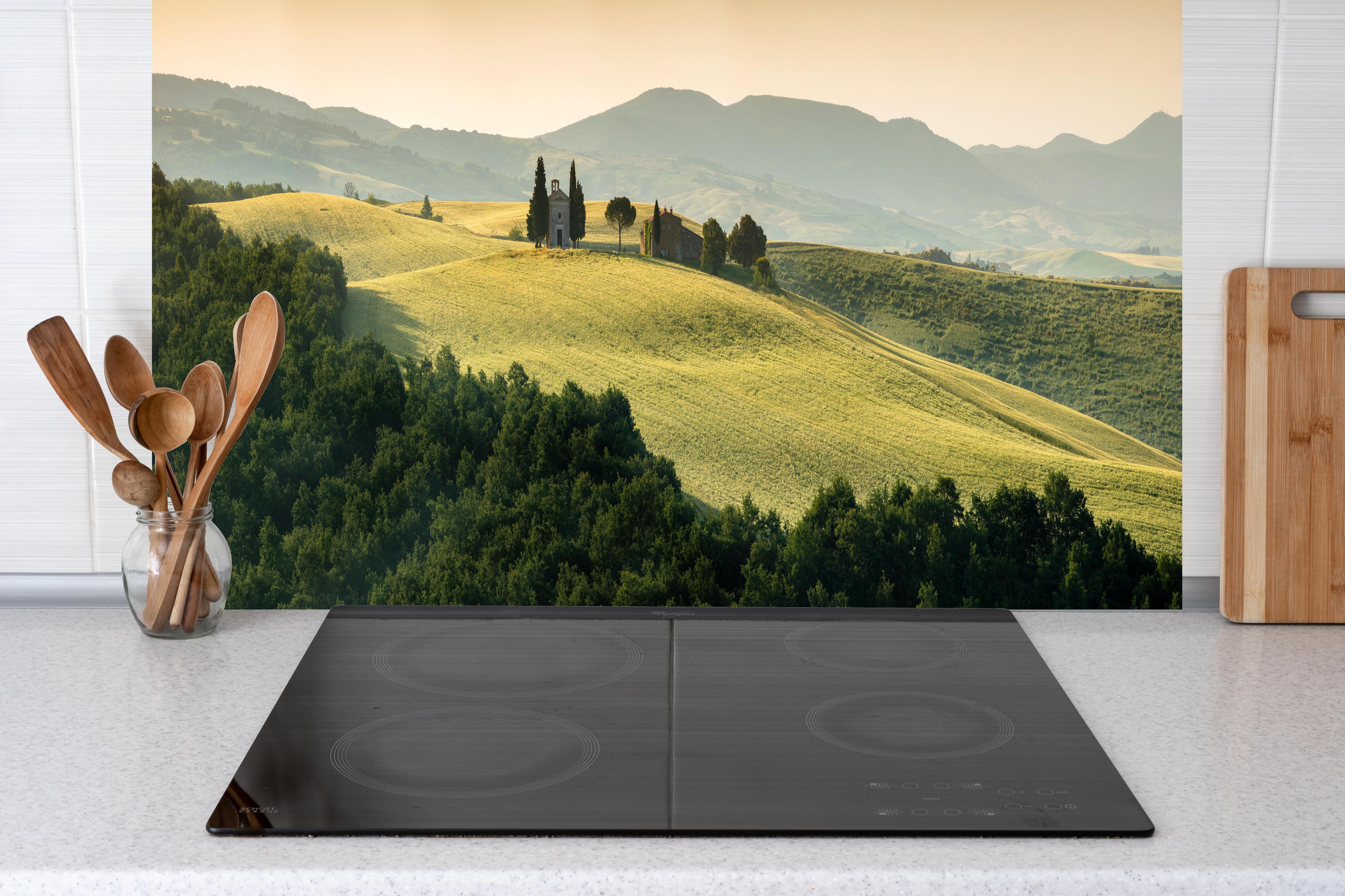 Küche - Toskanische Hügel in Goldgrün hinter Cerankochfeld und Holz-Kochutensilien
