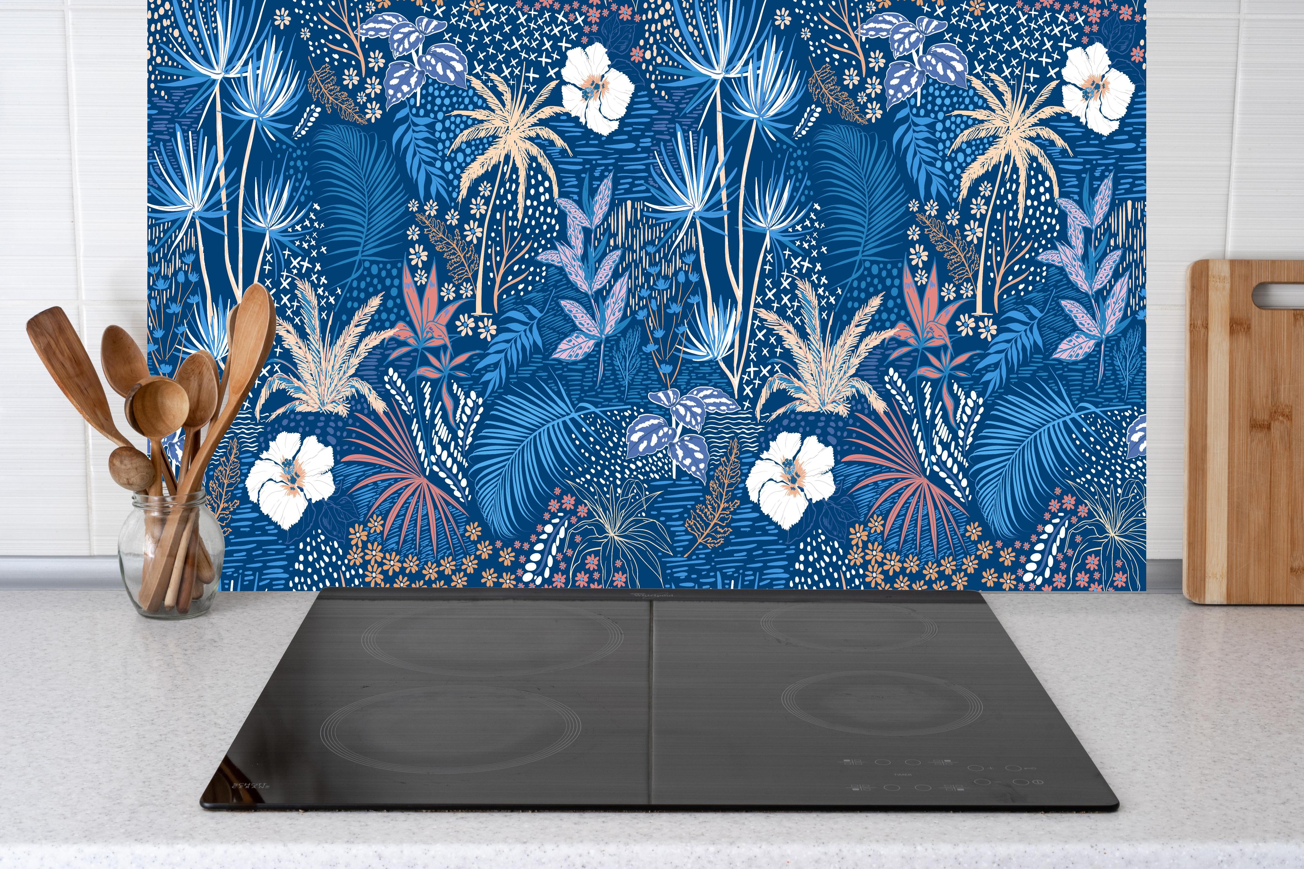 Küche - Tropische Azurblätter hinter Cerankochfeld und Holz-Kochutensilien