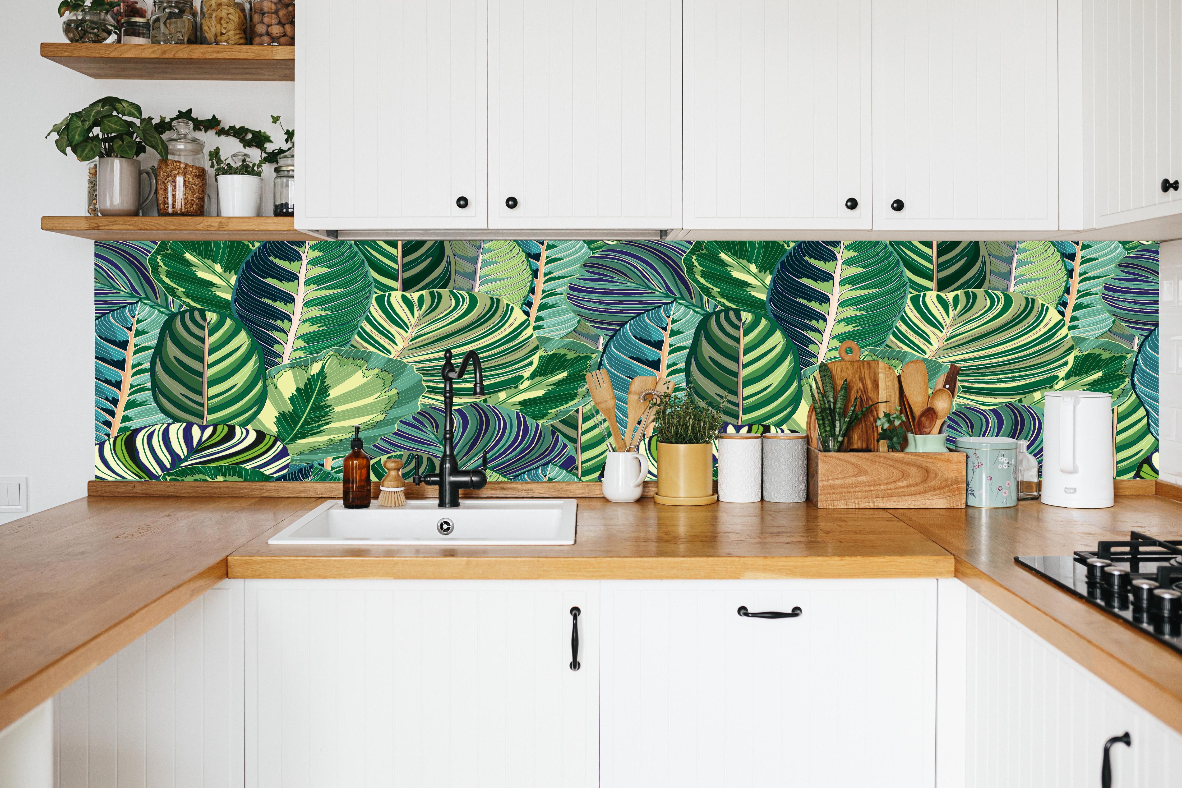 Küche - Tropische Blätter Grün-Türkis-Lila in weißer Küche hinter Gewürzen und Kochlöffeln aus Holz