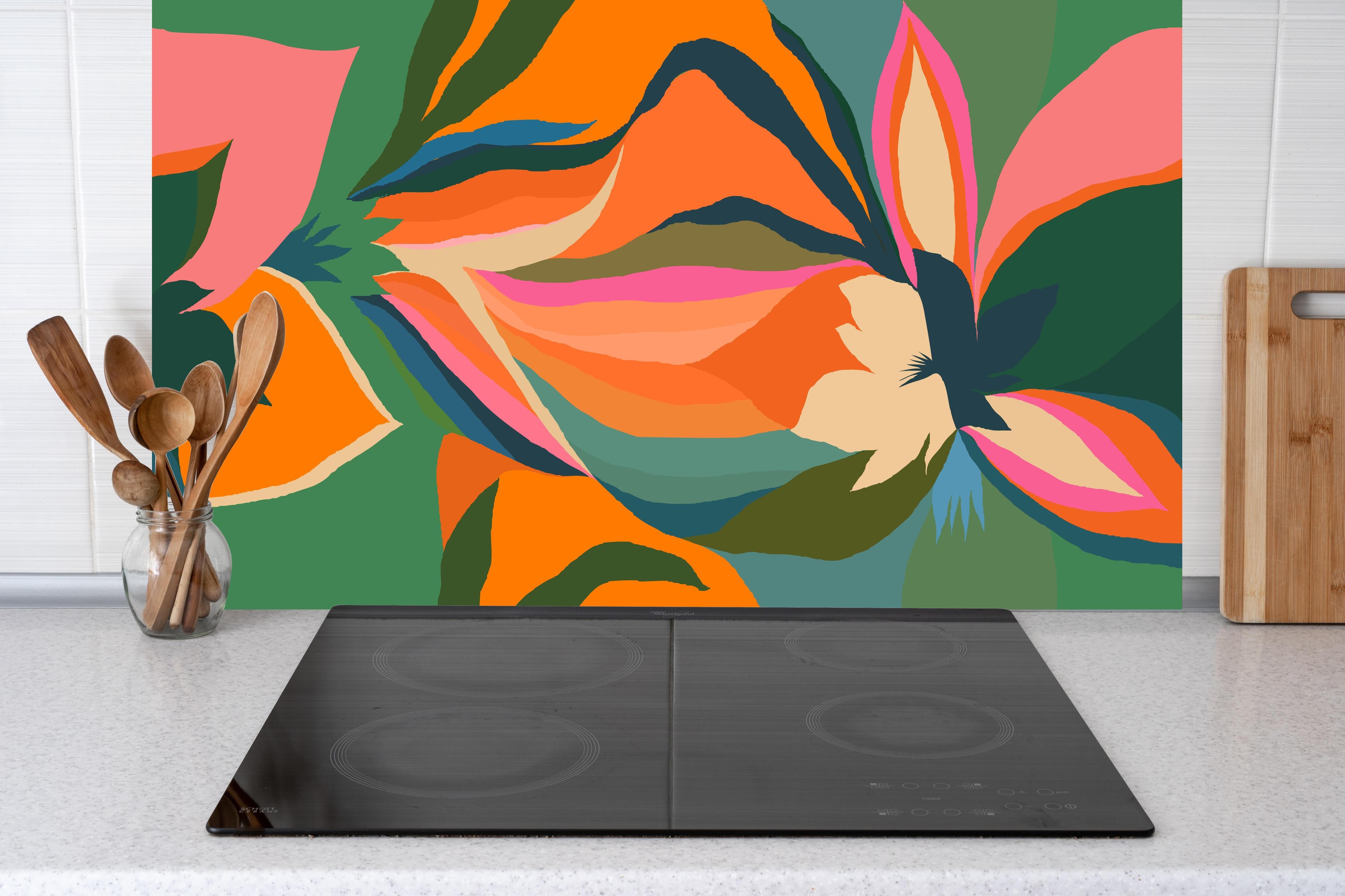 Küche - Tropische Blüten in Orange hinter Cerankochfeld und Holz-Kochutensilien