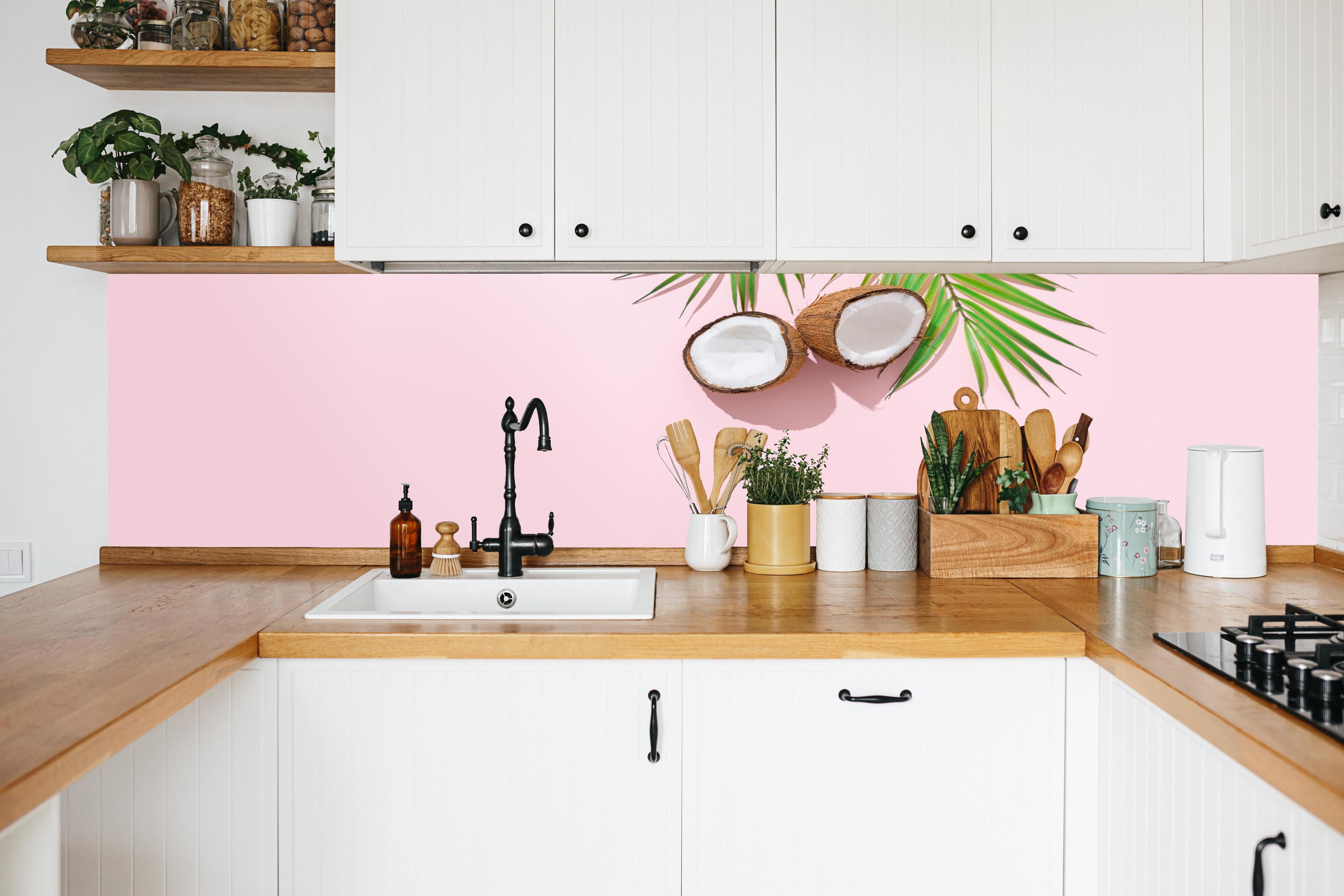 Küche - Tropische Kokosnuss auf Rosa in weißer Küche hinter Gewürzen und Kochlöffeln aus Holz