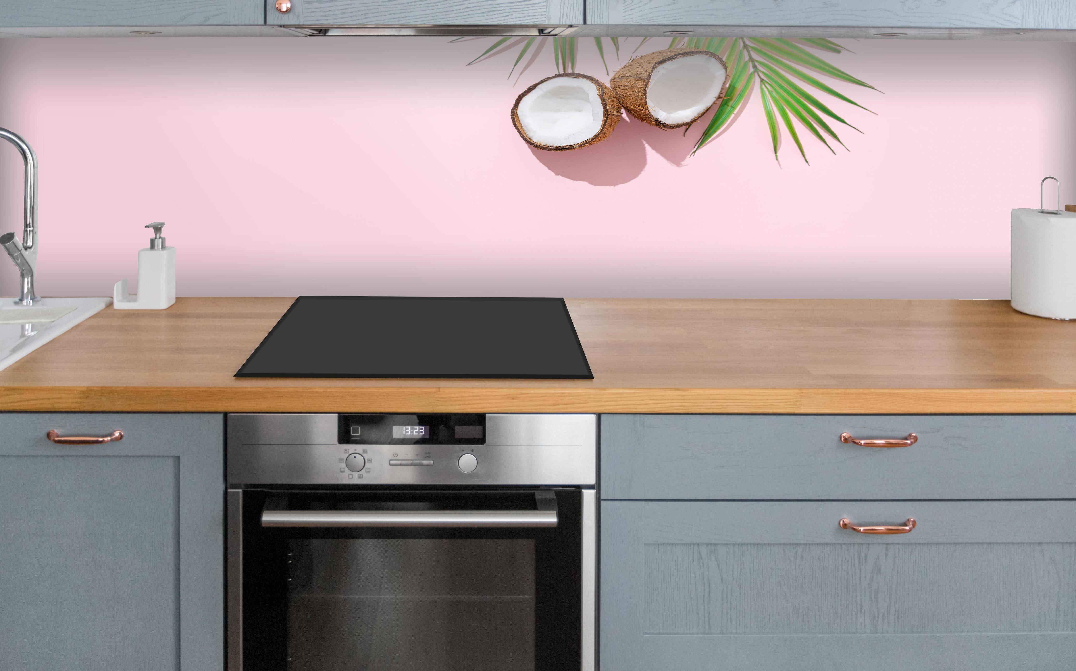 Küche - Tropische Kokosnuss auf Rosa über polierter Holzarbeitsplatte mit Cerankochfeld