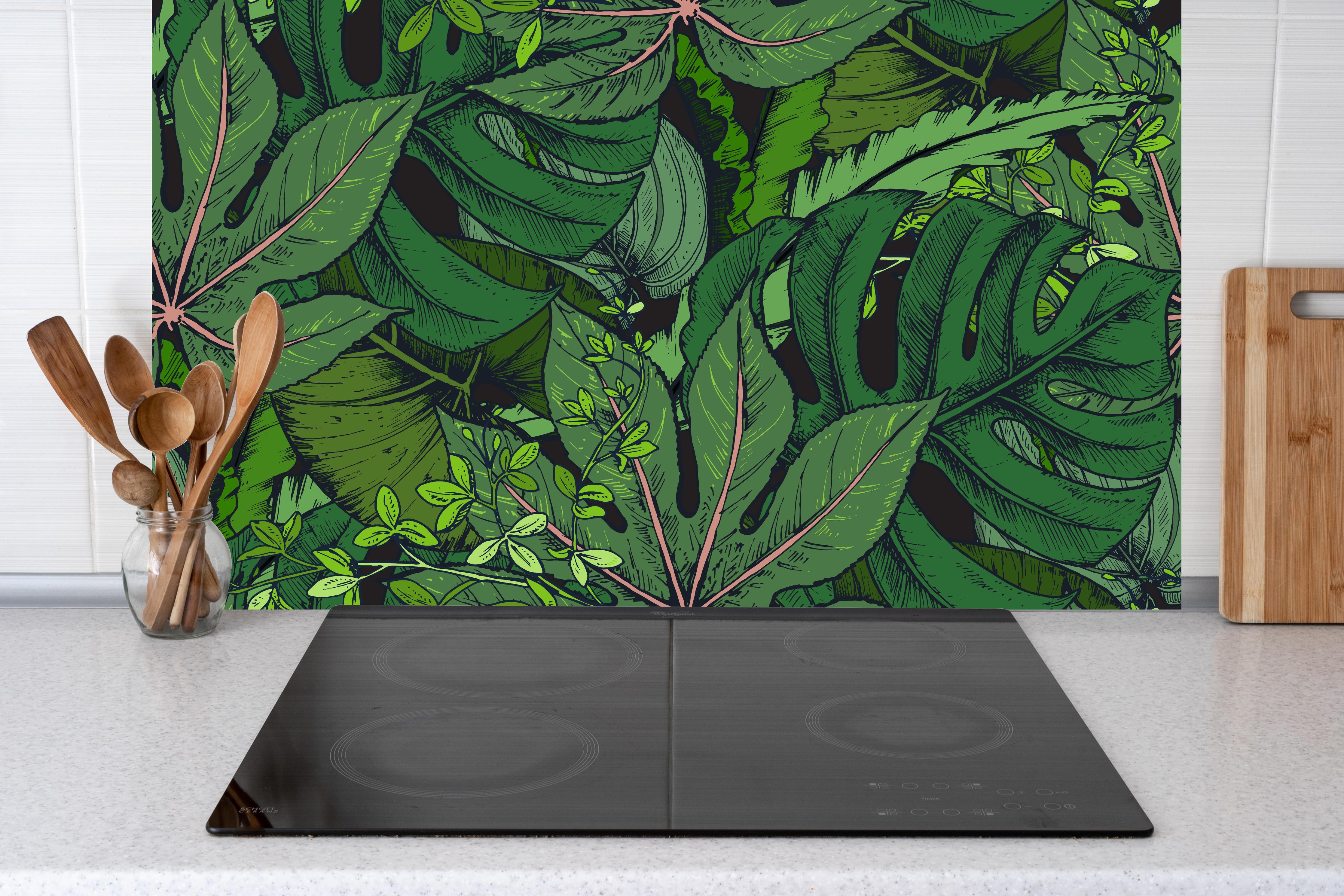 Küche - Tropische Monstera-Blätter Grün hinter Cerankochfeld und Holz-Kochutensilien