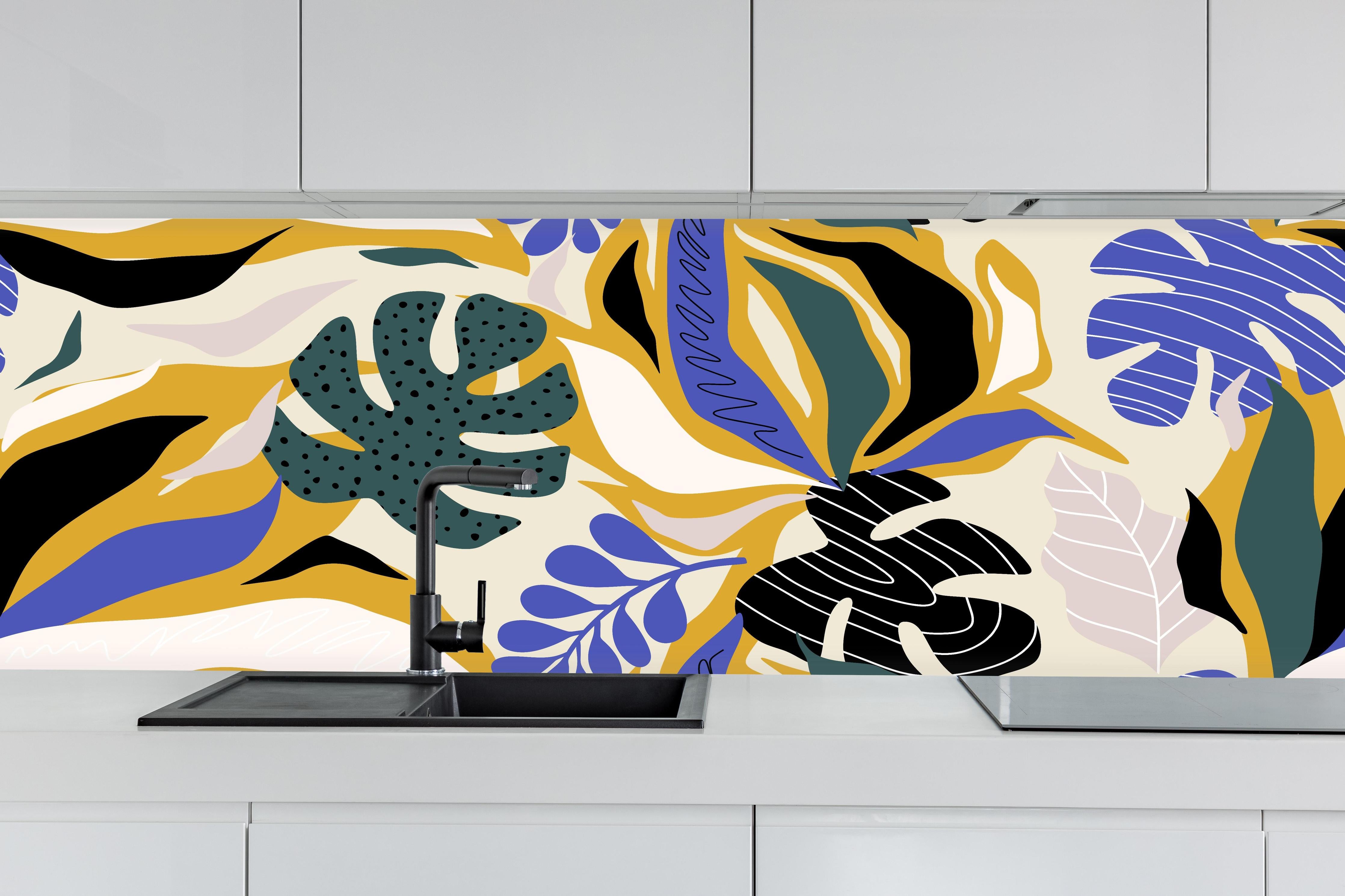 Küche - Tropisches Blattmuster Gelb-Blau hinter weißen Hochglanz-Küchenregalen und schwarzem Wasserhahn