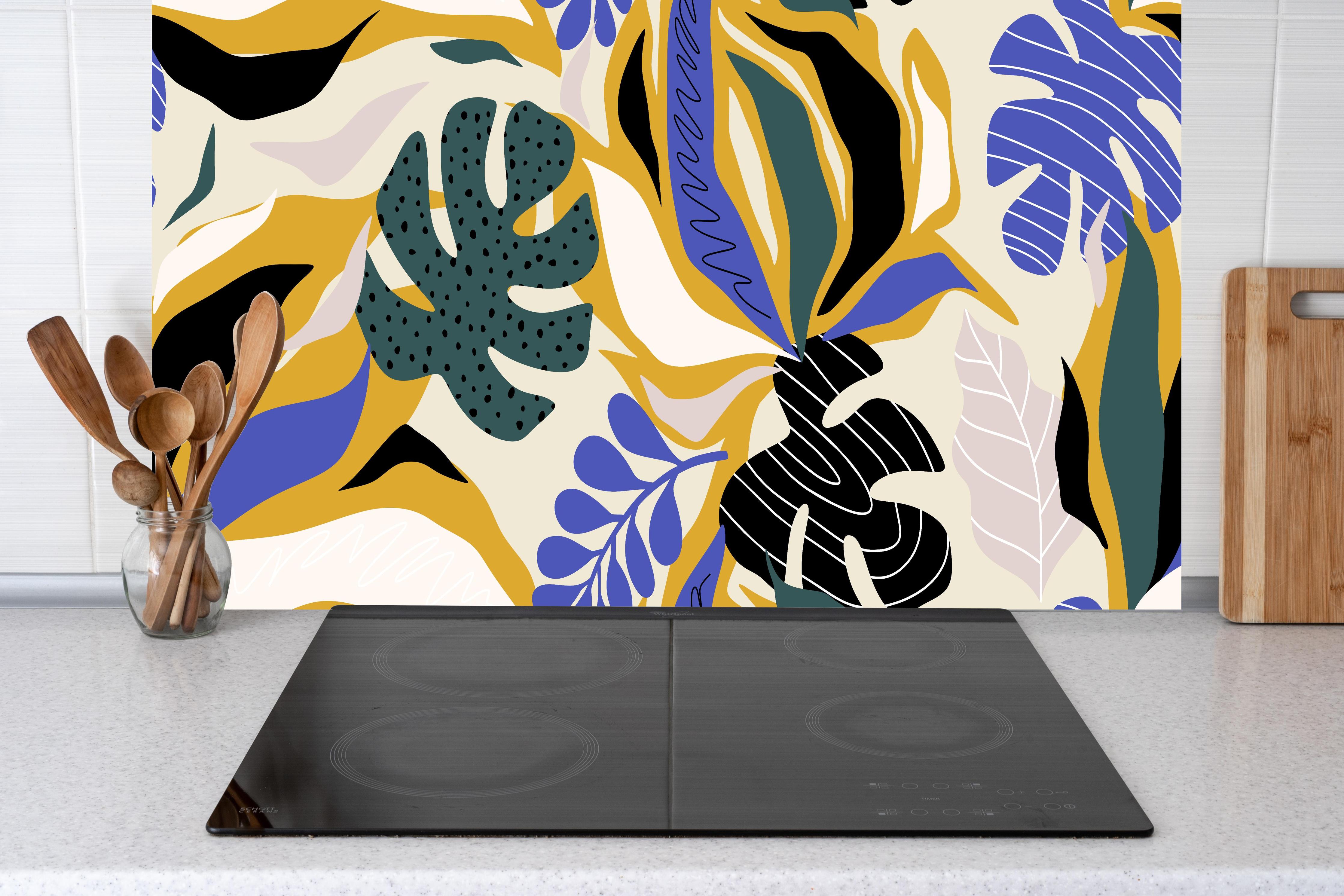 Küche - Tropisches Blattmuster Gelb-Blau hinter Cerankochfeld und Holz-Kochutensilien