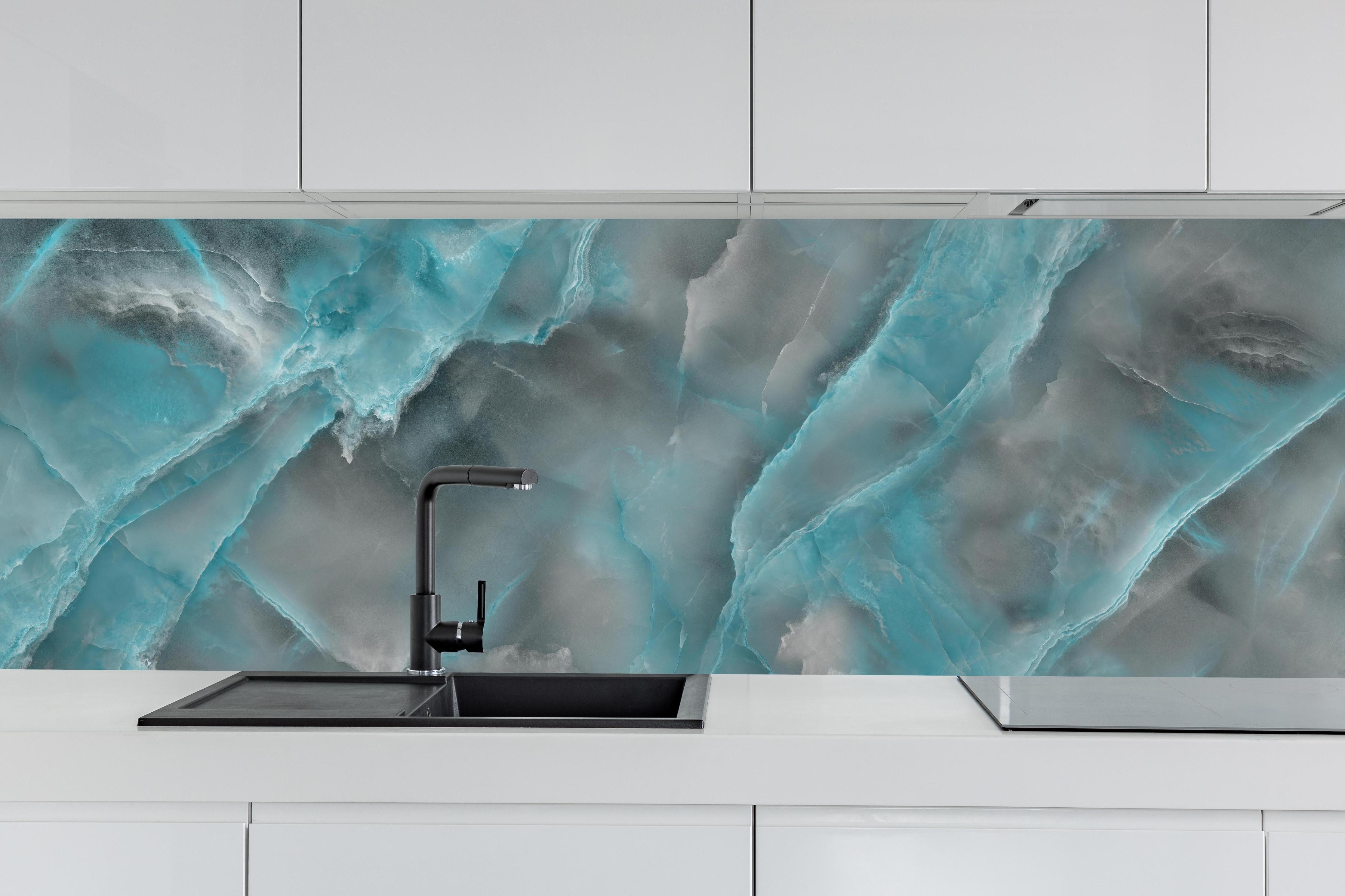 Küche - Türkis-Grau-Steinmuster hinter weißen Hochglanz-Küchenregalen und schwarzem Wasserhahn