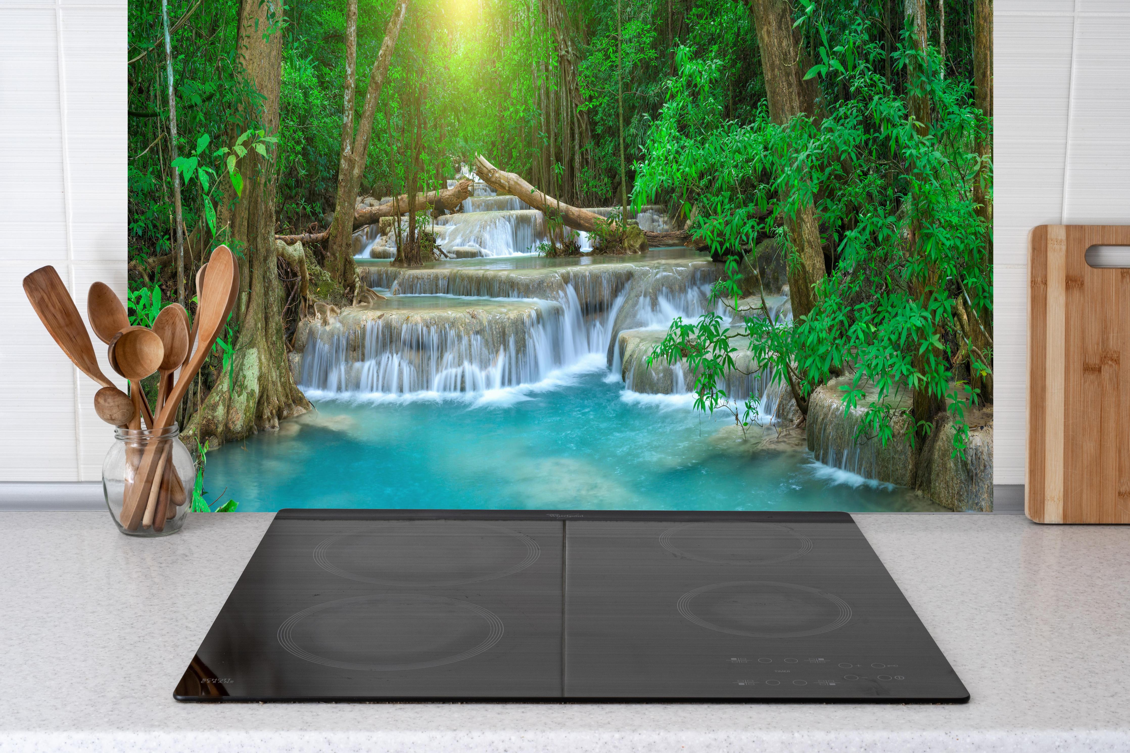 Küche - Türkis-Wasserfall im grünen Wald hinter Cerankochfeld und Holz-Kochutensilien