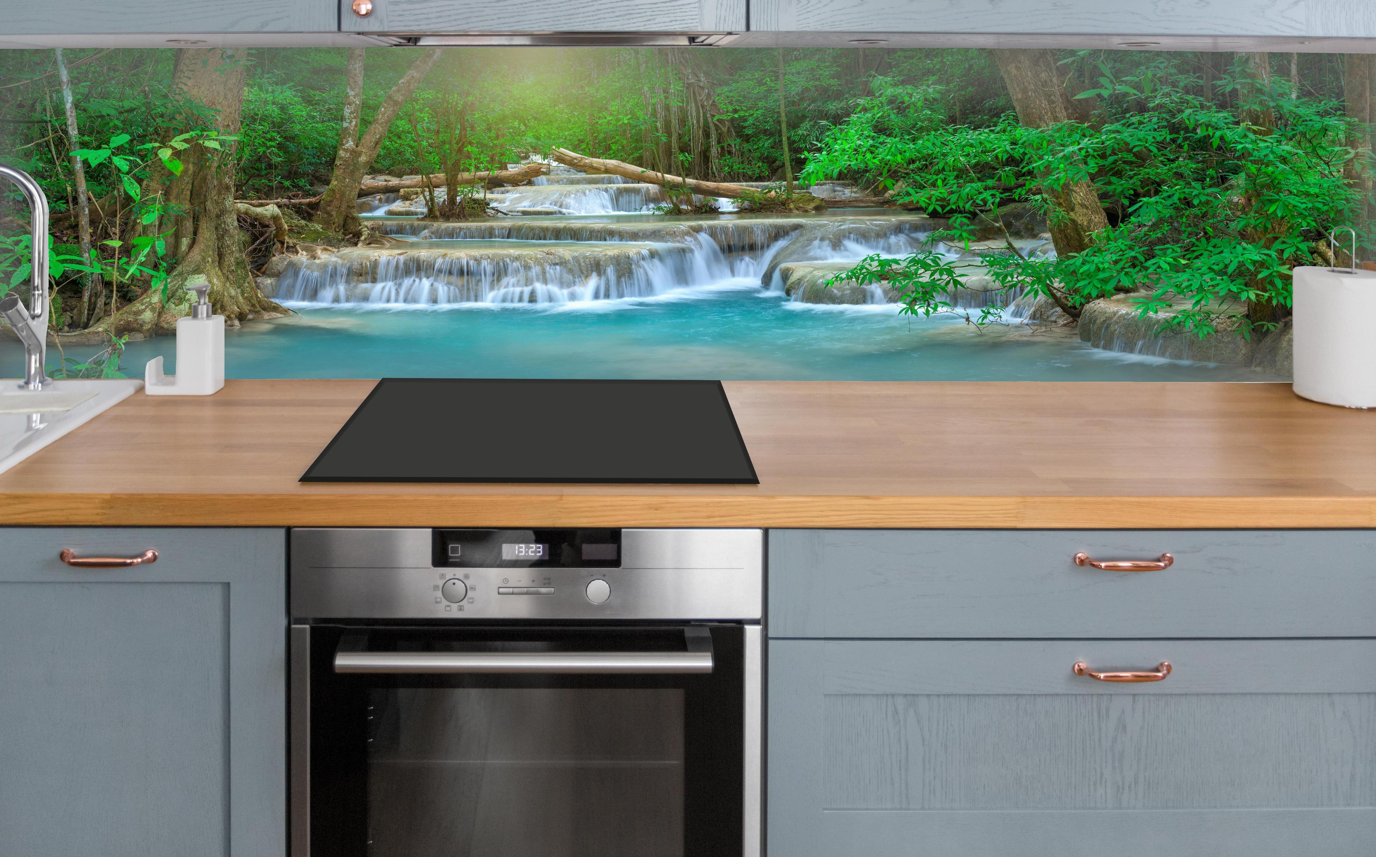 Küche - Türkis-Wasserfall im grünen Wald über polierter Holzarbeitsplatte mit Cerankochfeld
