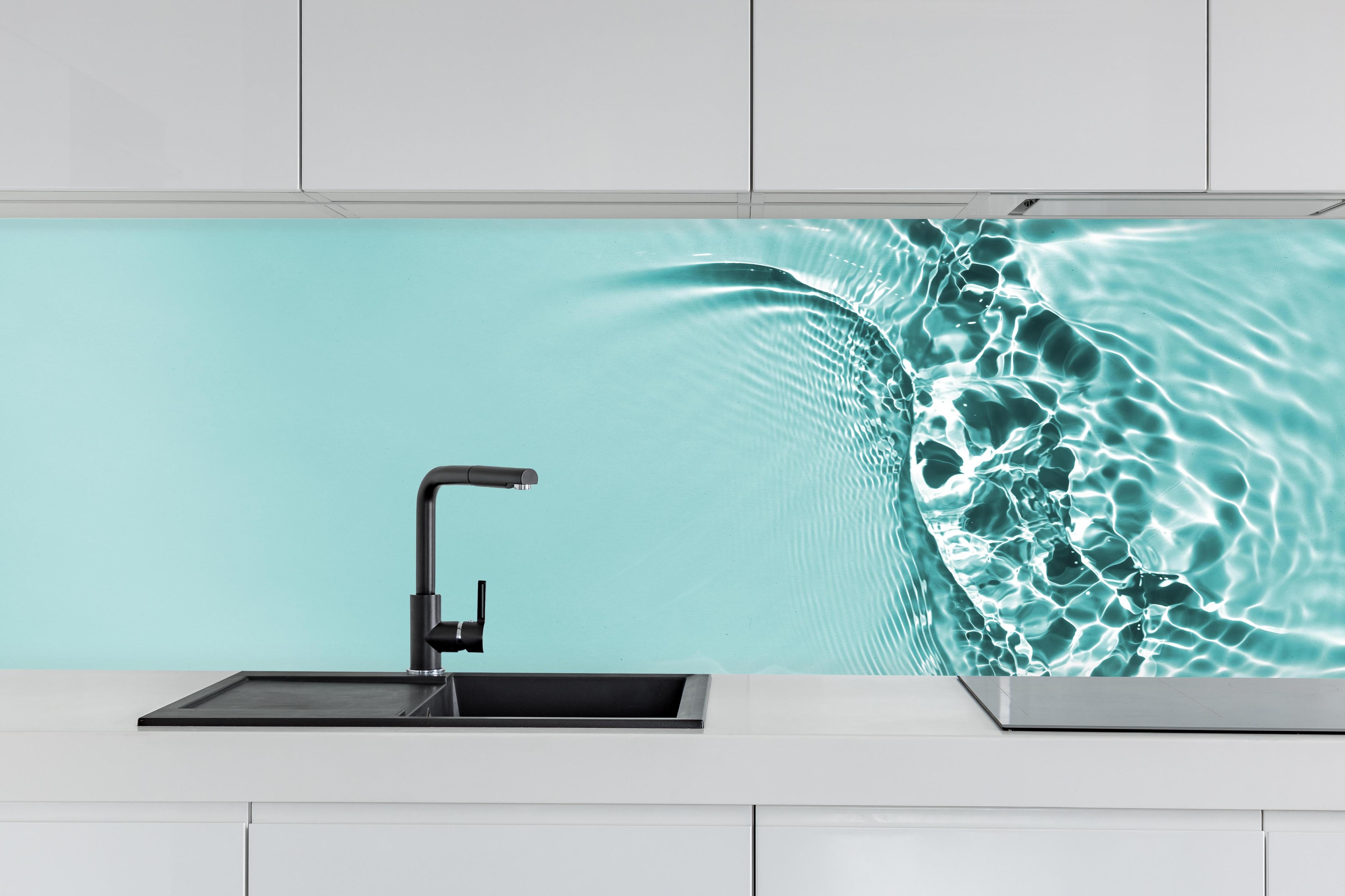 Küche - Türkisblaues Wasser mit Lichtreflexen hinter weißen Hochglanz-Küchenregalen und schwarzem Wasserhahn