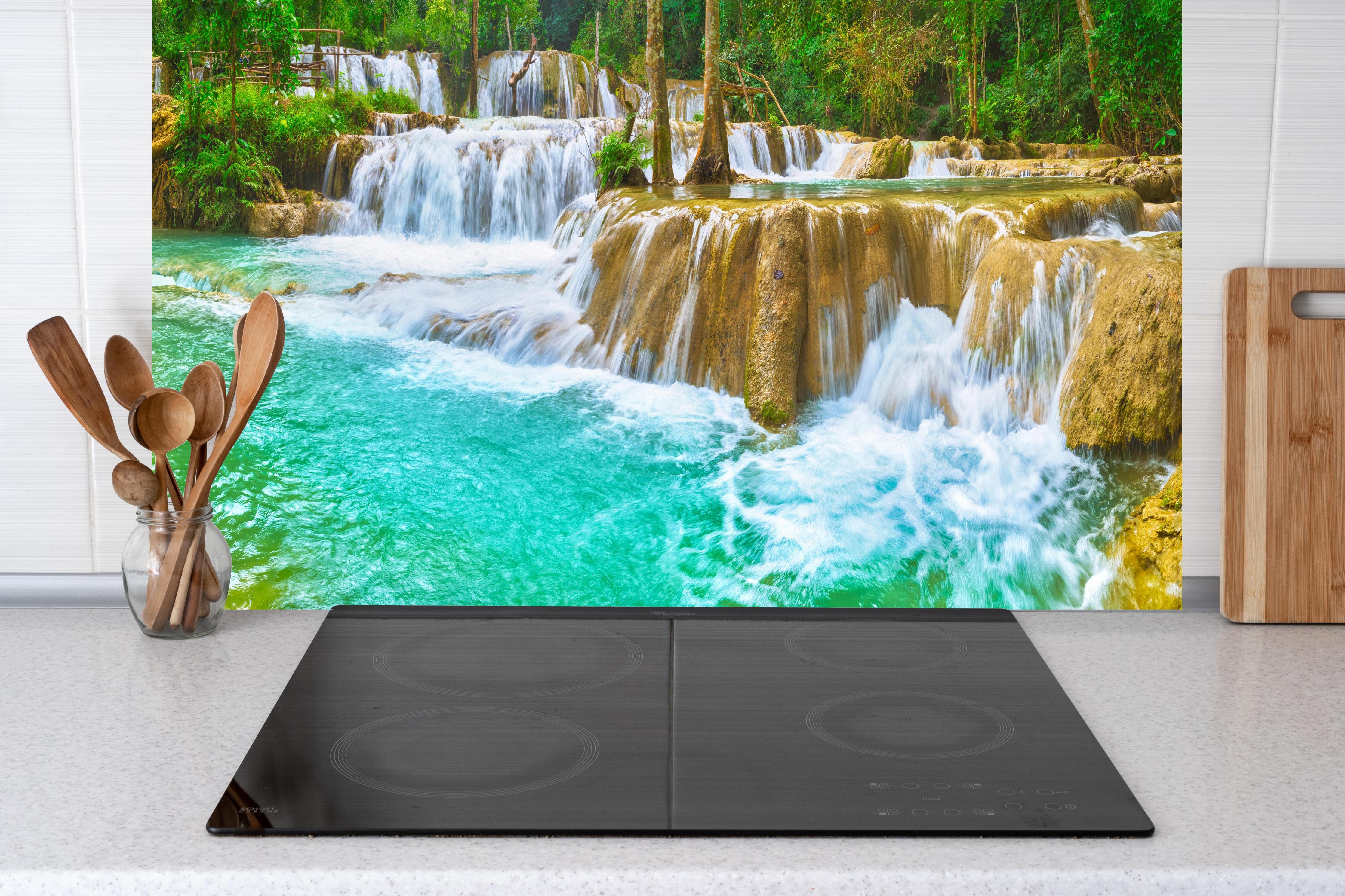 Küche - Türkisgrüner Stufen-Wasserfall hinter Cerankochfeld und Holz-Kochutensilien