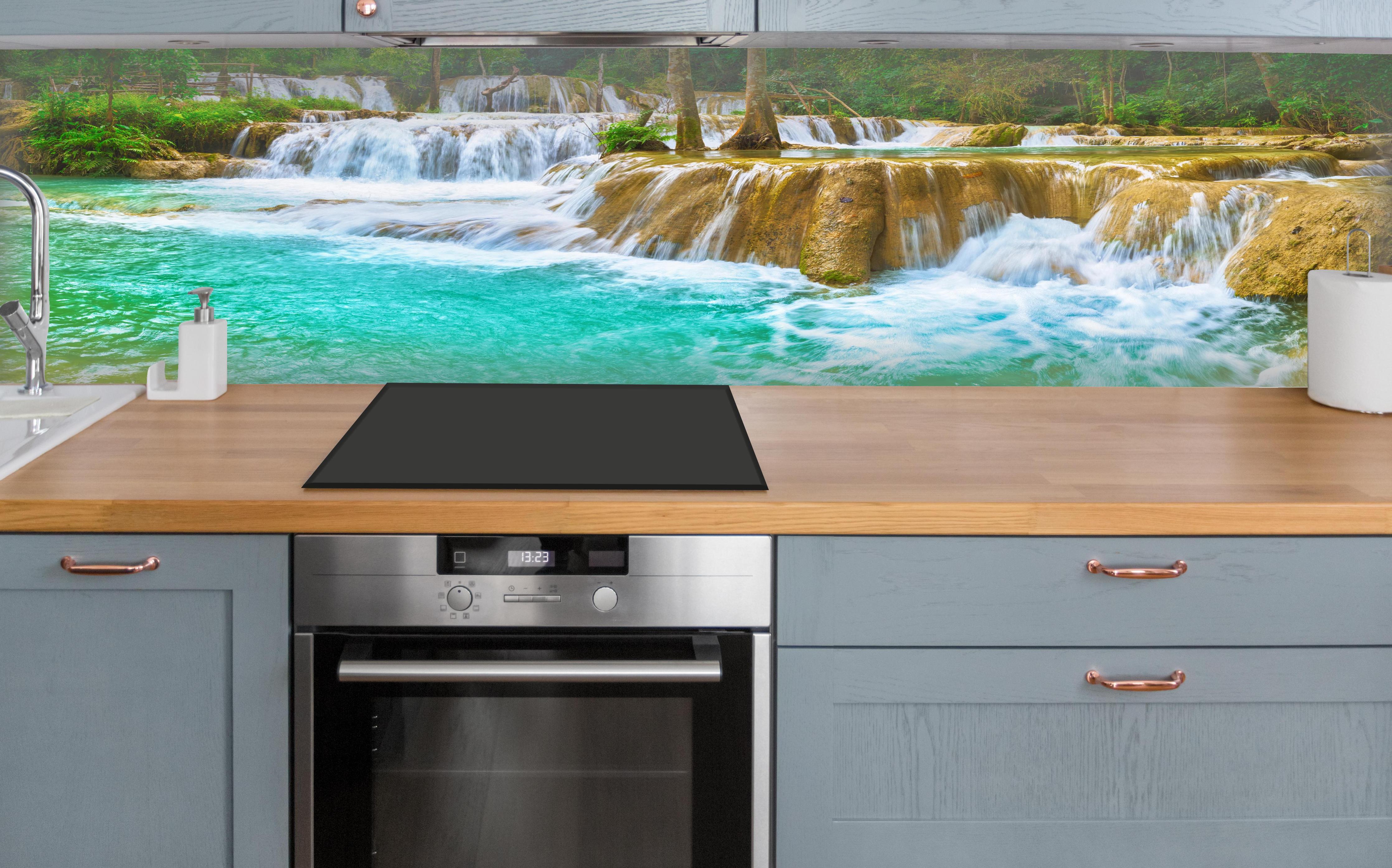 Küche - Türkisgrüner Stufen-Wasserfall über polierter Holzarbeitsplatte mit Cerankochfeld