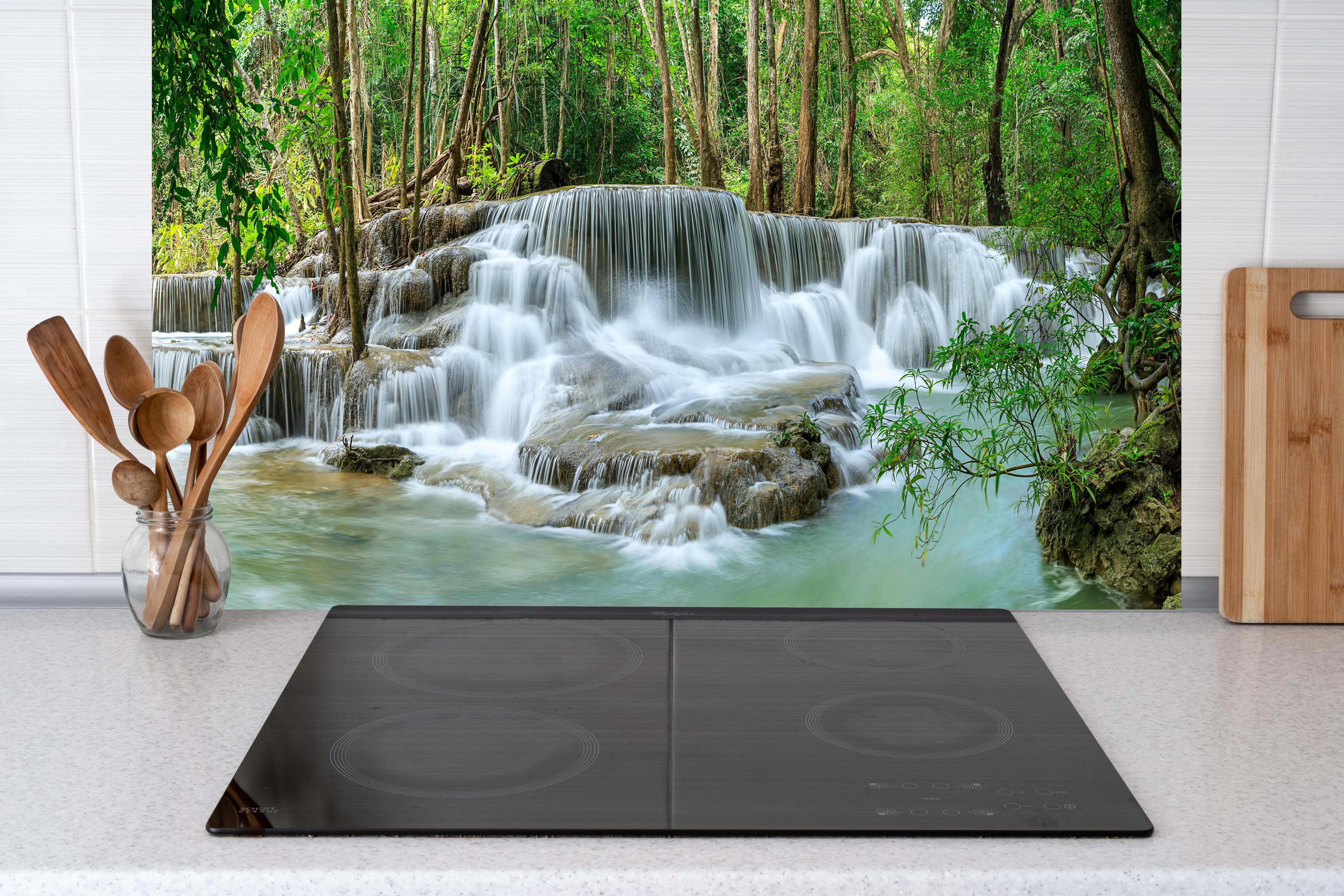 Küche - Türkisgrüner Wasserfall im Wald hinter Cerankochfeld und Holz-Kochutensilien