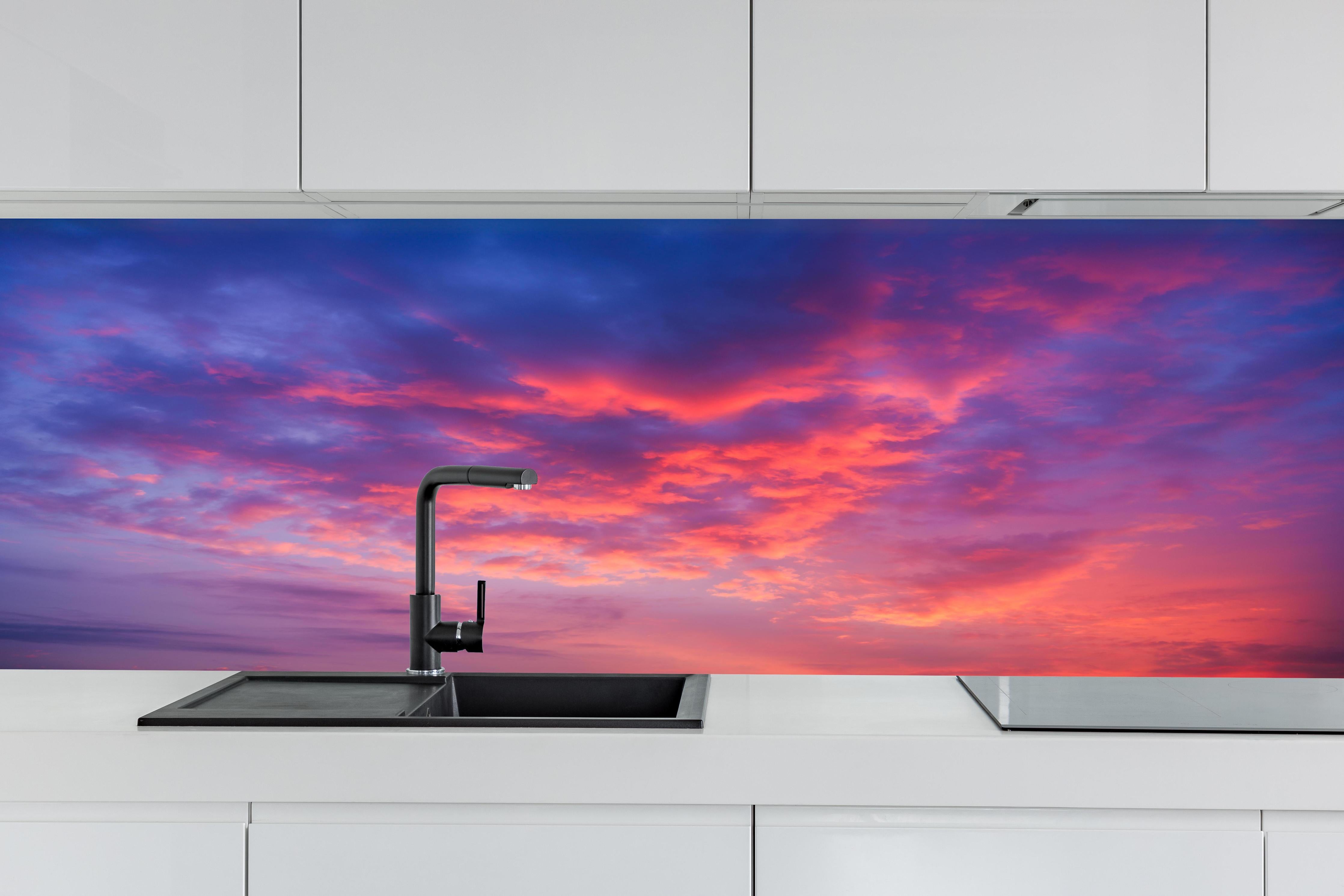 Küche - Violett-Pinker Sonnenuntergang hinter weißen Hochglanz-Küchenregalen und schwarzem Wasserhahn