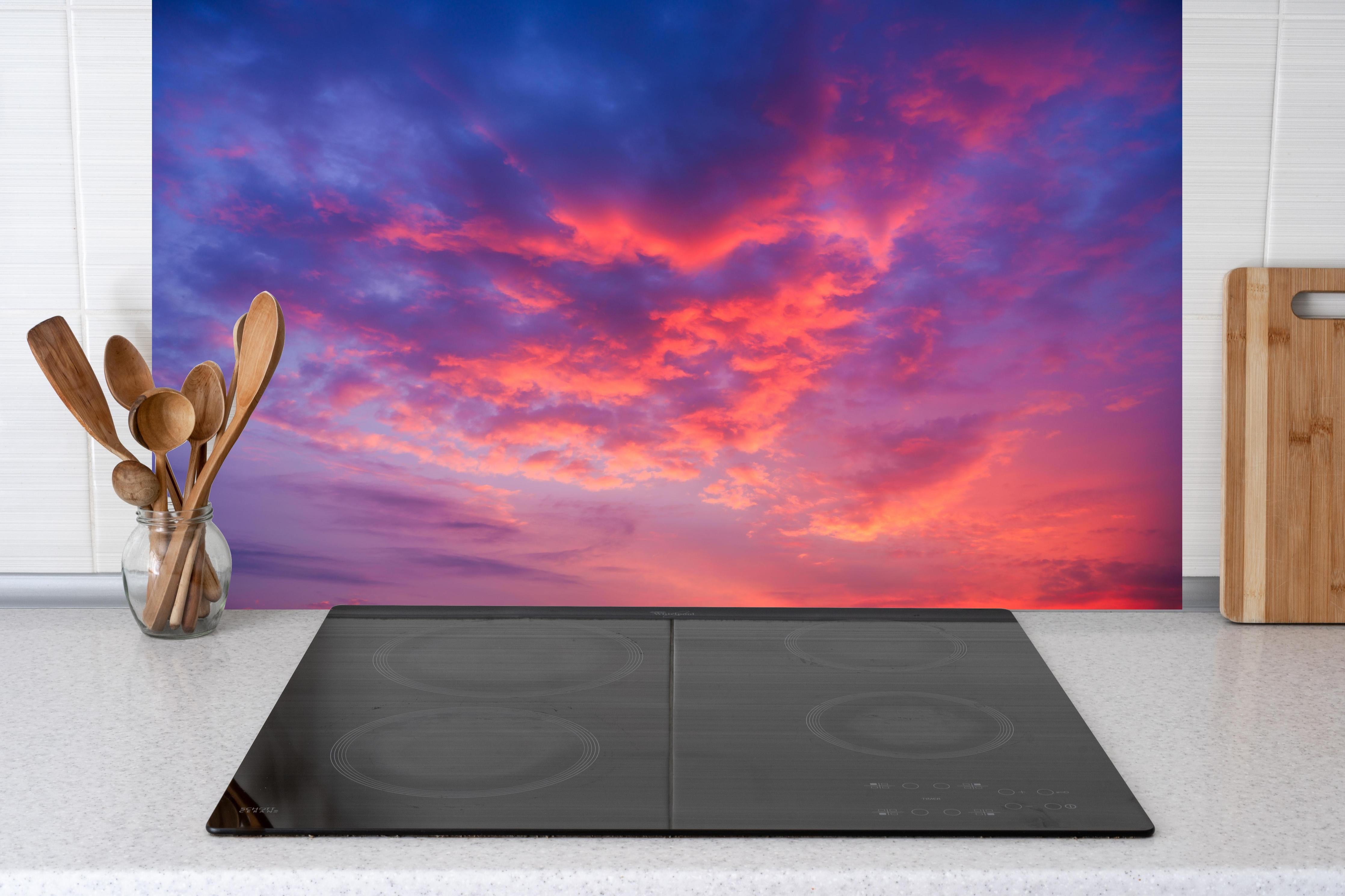 Küche - Violett-Pinker Sonnenuntergang hinter Cerankochfeld und Holz-Kochutensilien