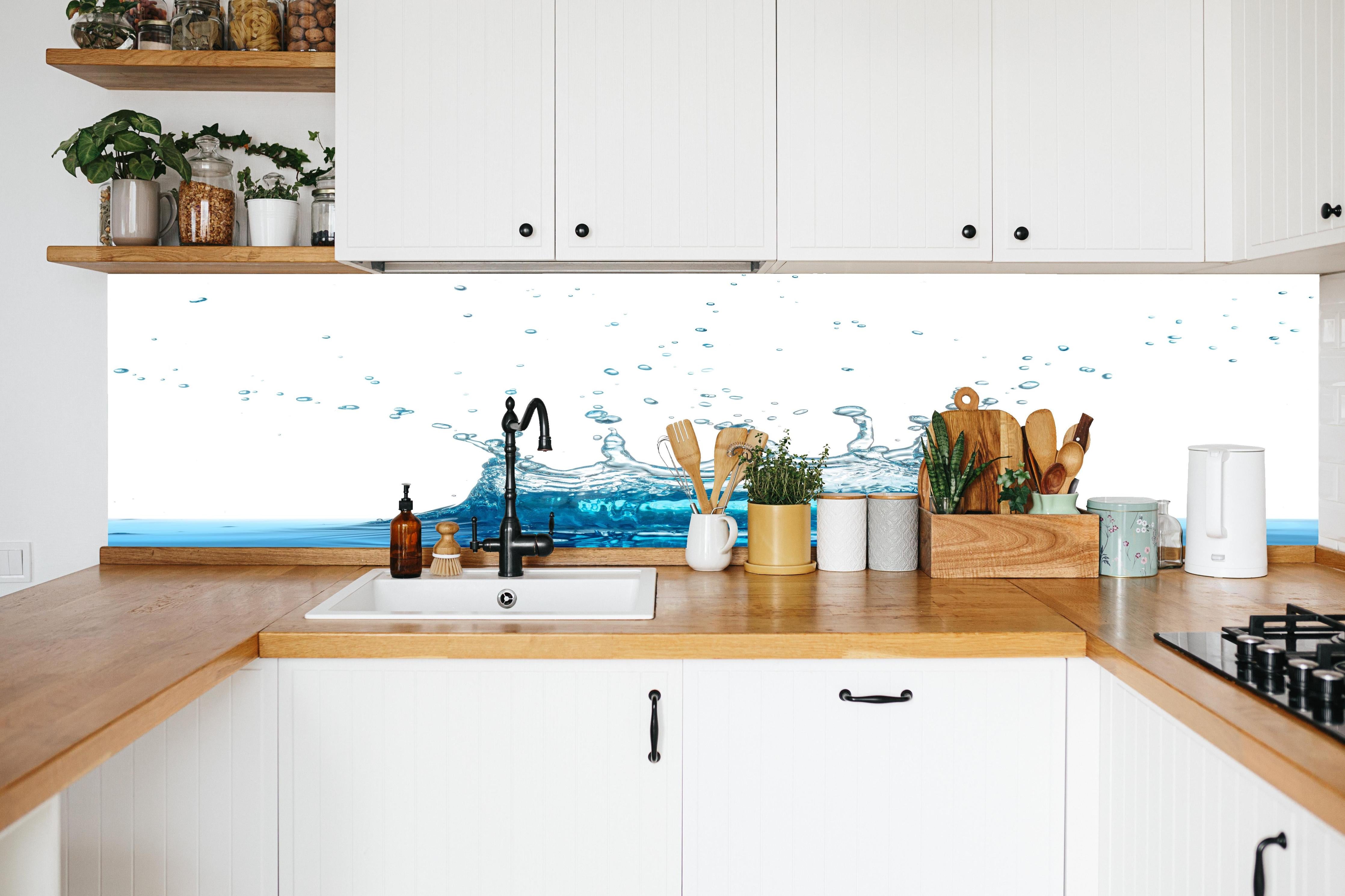 Küche - Wassersplash in Blau und Weiß in weißer Küche hinter Gewürzen und Kochlöffeln aus Holz