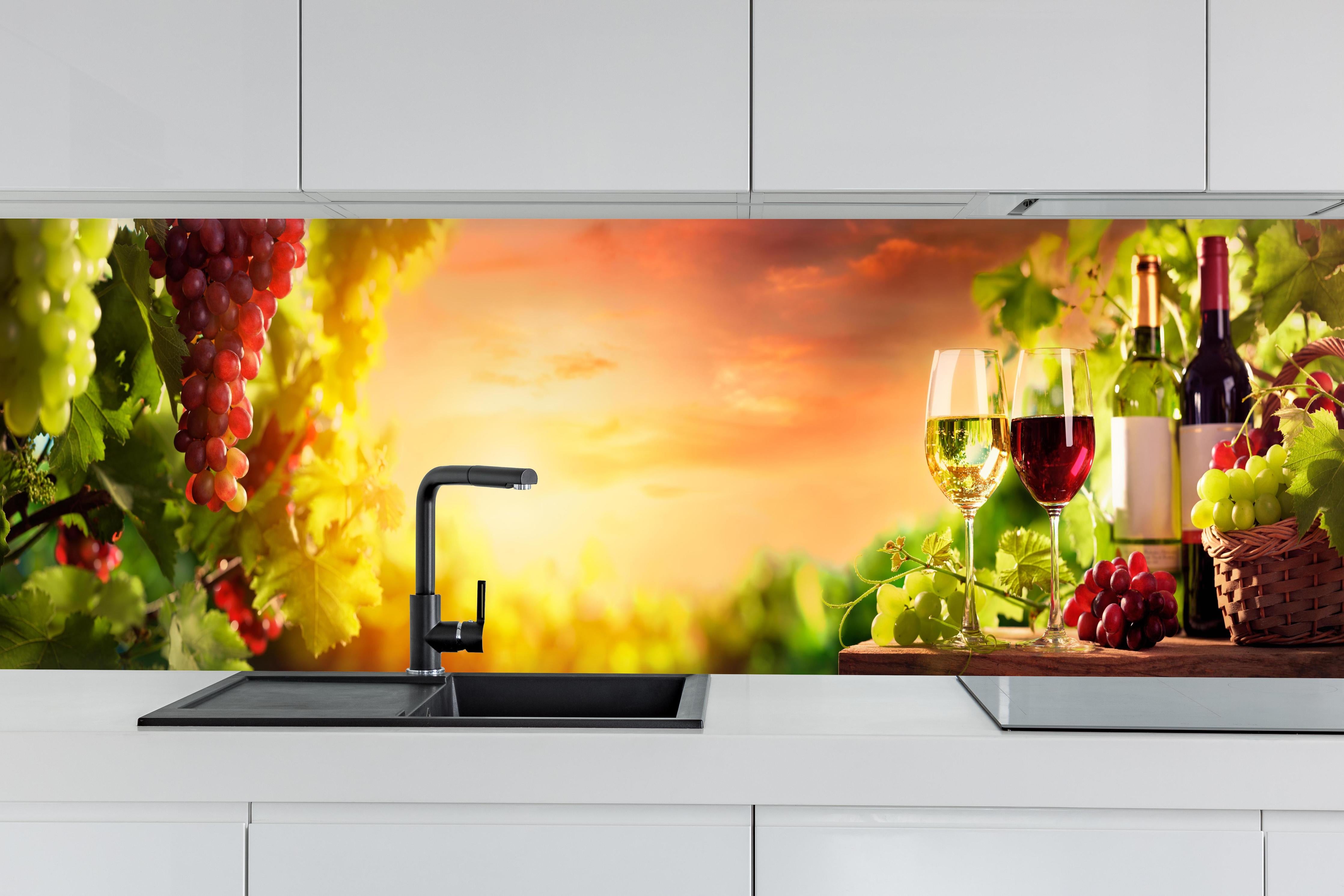 Küche - Weintrauben und Wein im Sonnenuntergang hinter weißen Hochglanz-Küchenregalen und schwarzem Wasserhahn
