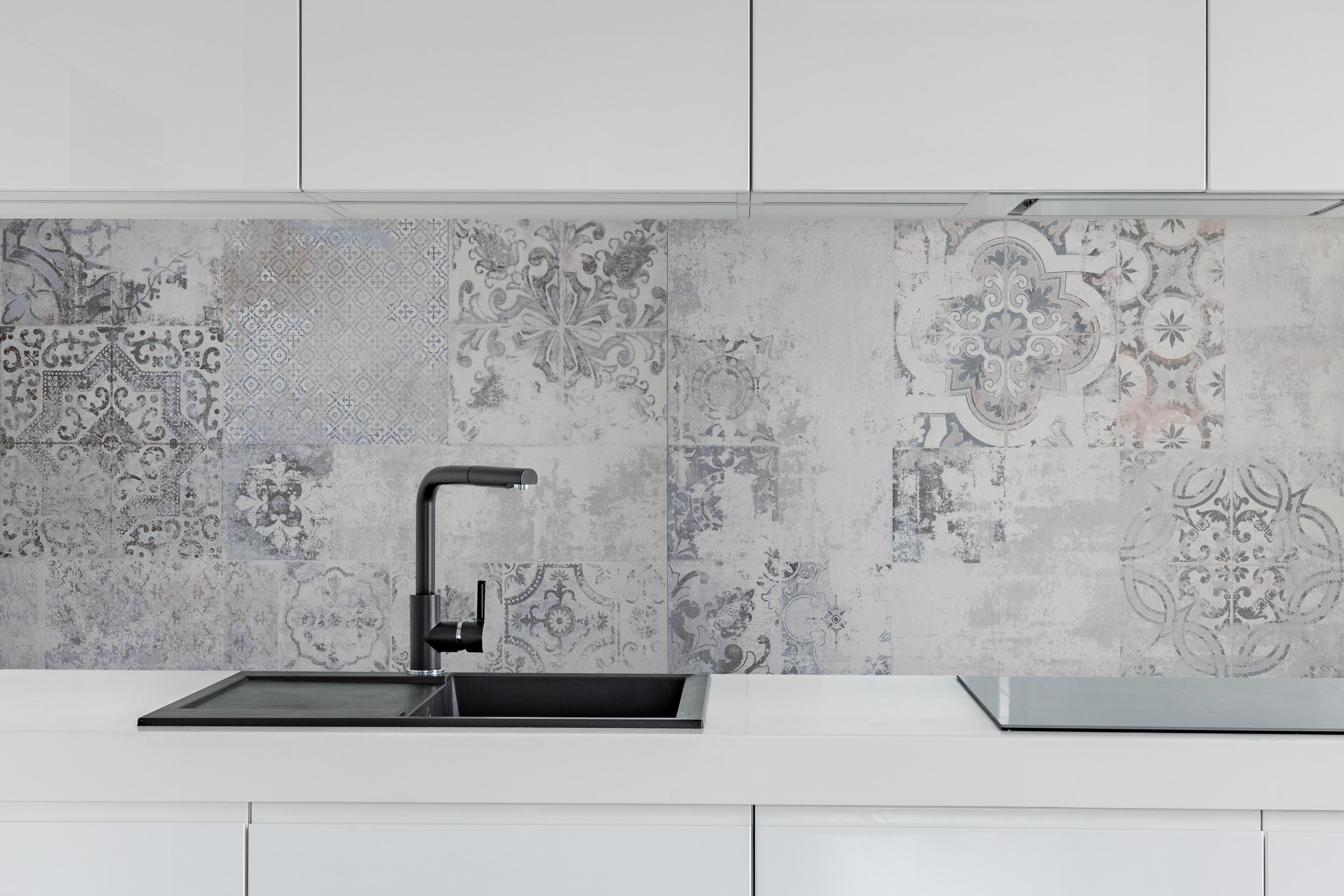 Küche - Weiß-Grau Vintage-Fliesen hinter weißen Hochglanz-Küchenregalen und schwarzem Wasserhahn