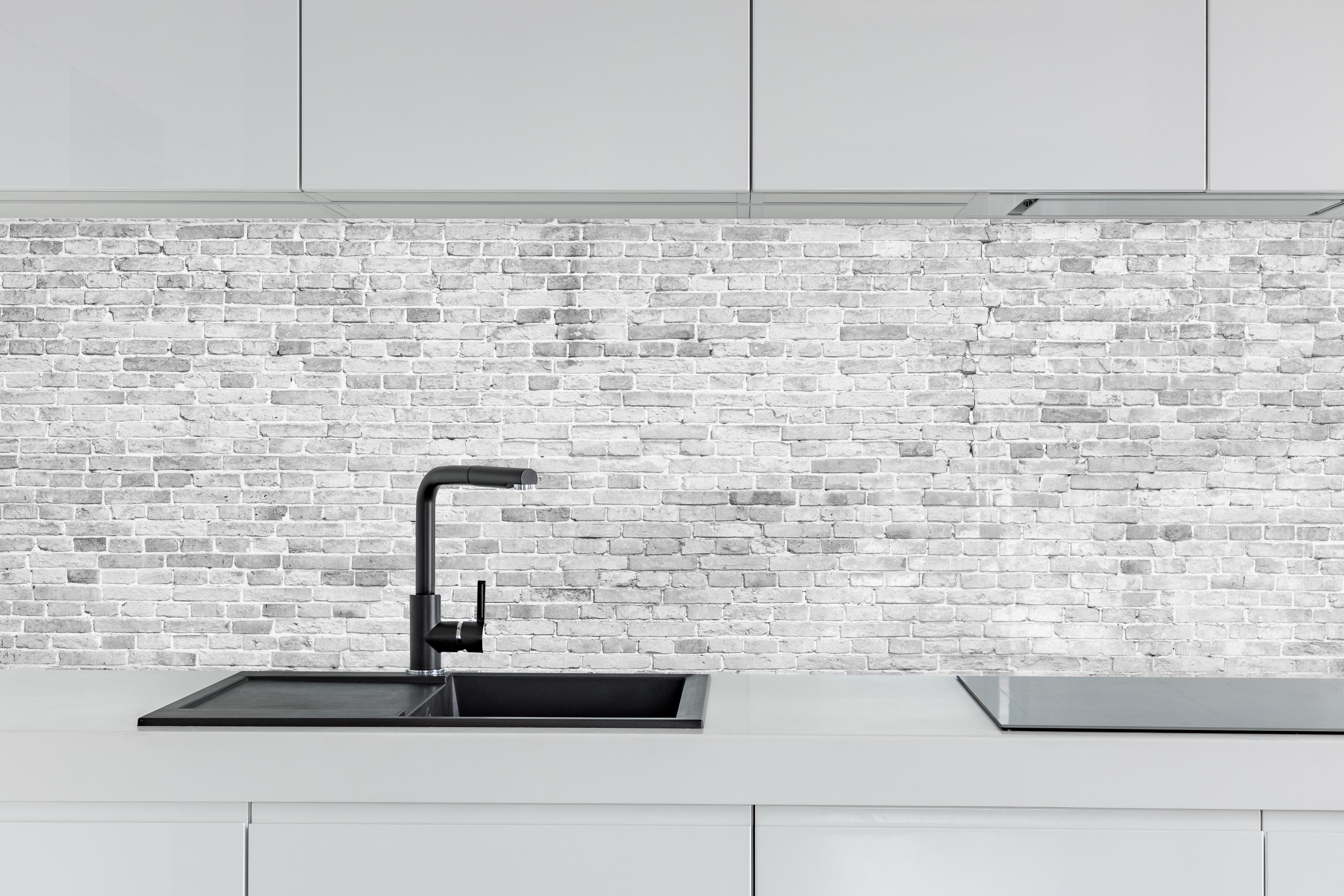 Küche - Weiß-Grau-Ziegeltextur hinter weißen Hochglanz-Küchenregalen und schwarzem Wasserhahn
