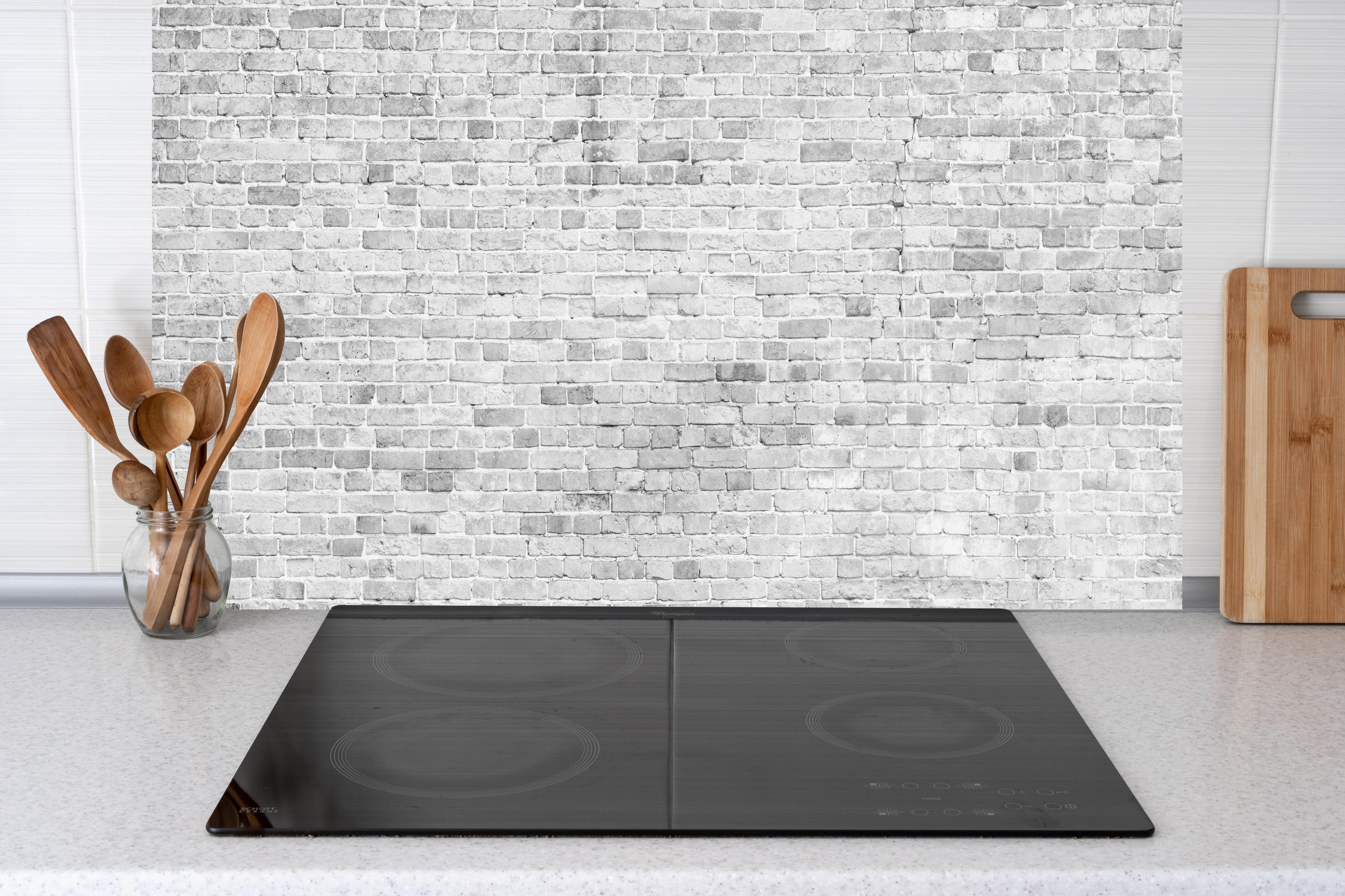 Küche - Weiß-Grau-Ziegeltextur hinter Cerankochfeld und Holz-Kochutensilien