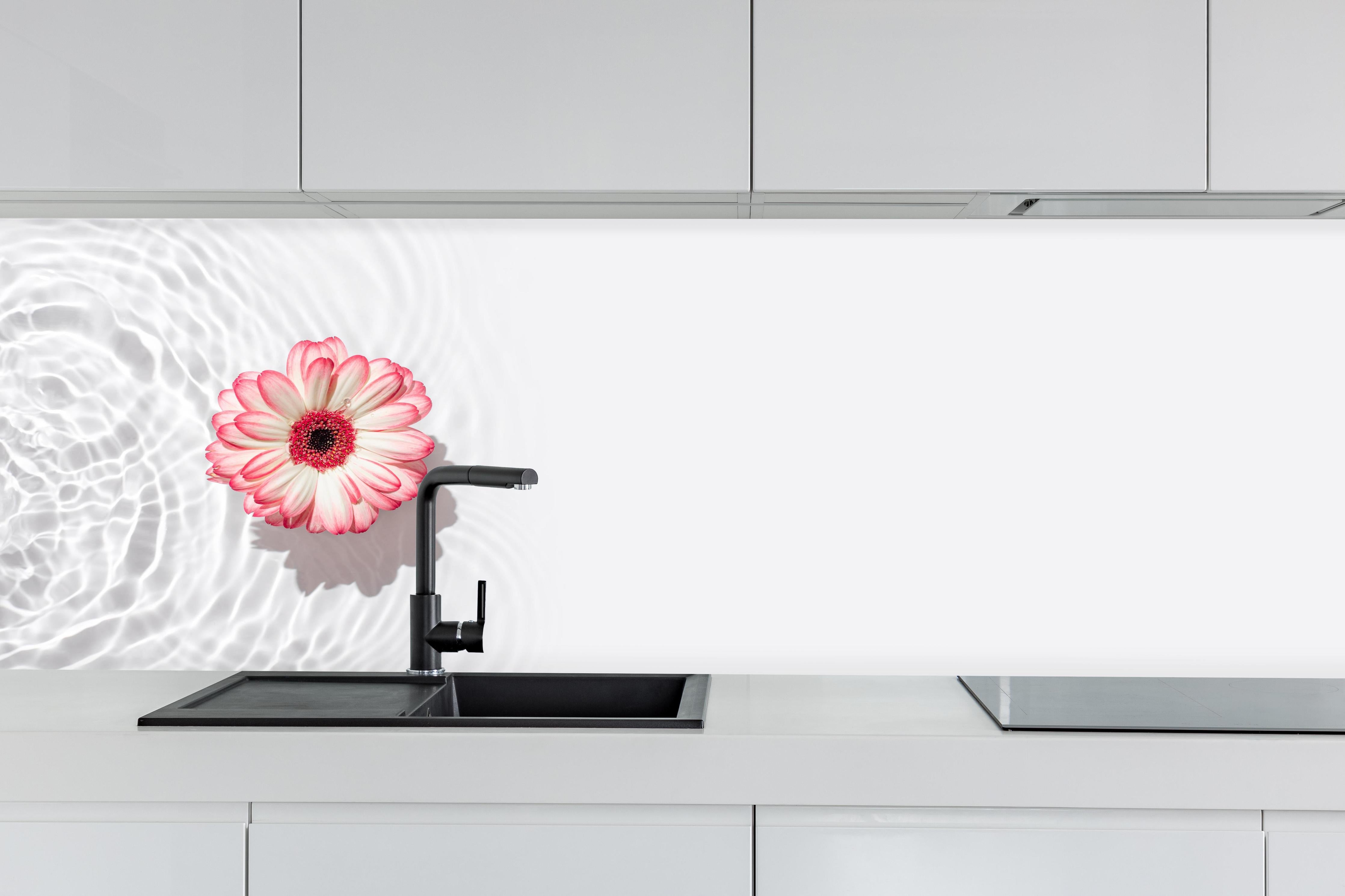 Küche - Weiß-Grau mit Rosa Gerbera hinter weißen Hochglanz-Küchenregalen und schwarzem Wasserhahn