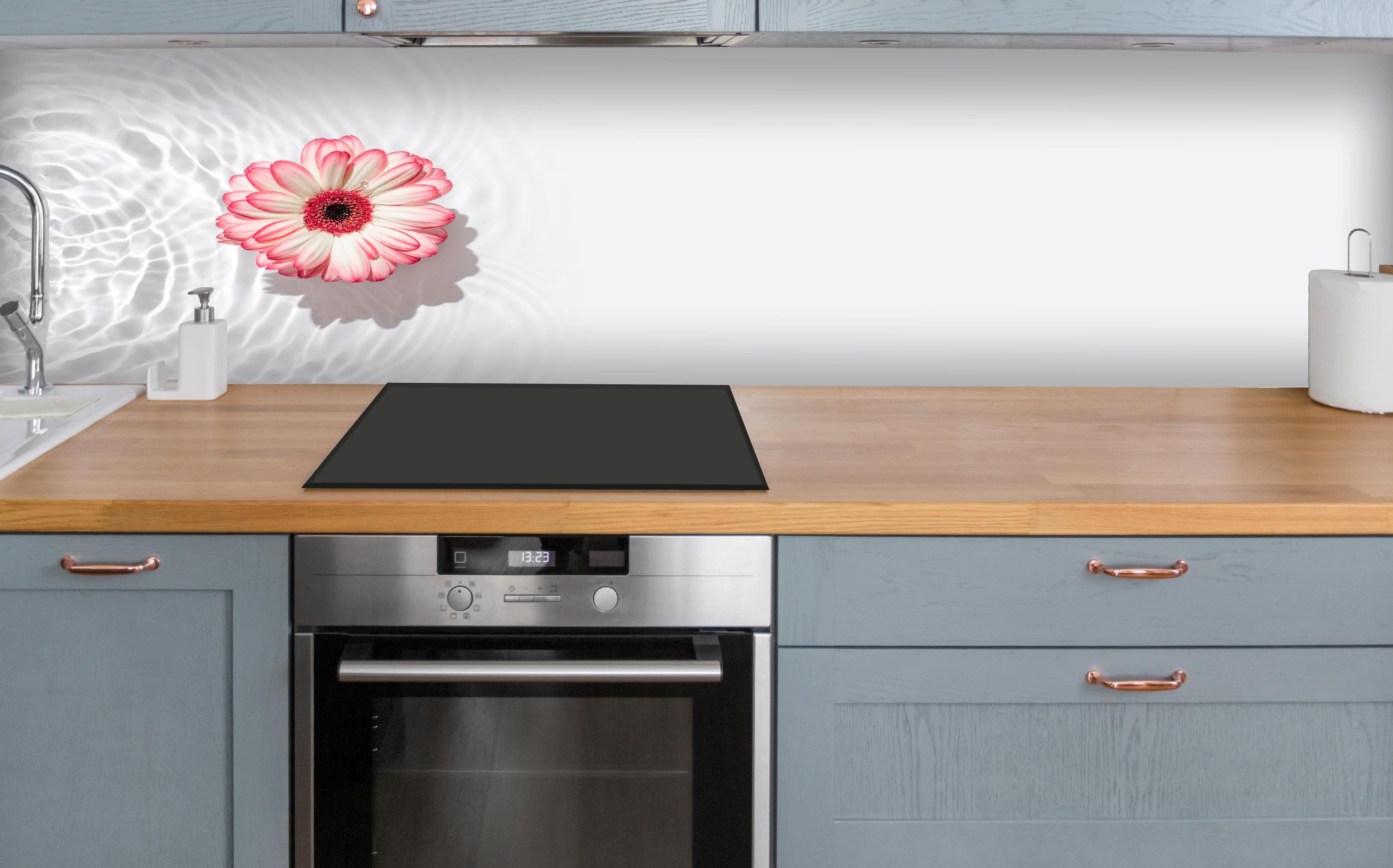 Küche - Weiß-Grau mit Rosa Gerbera über polierter Holzarbeitsplatte mit Cerankochfeld