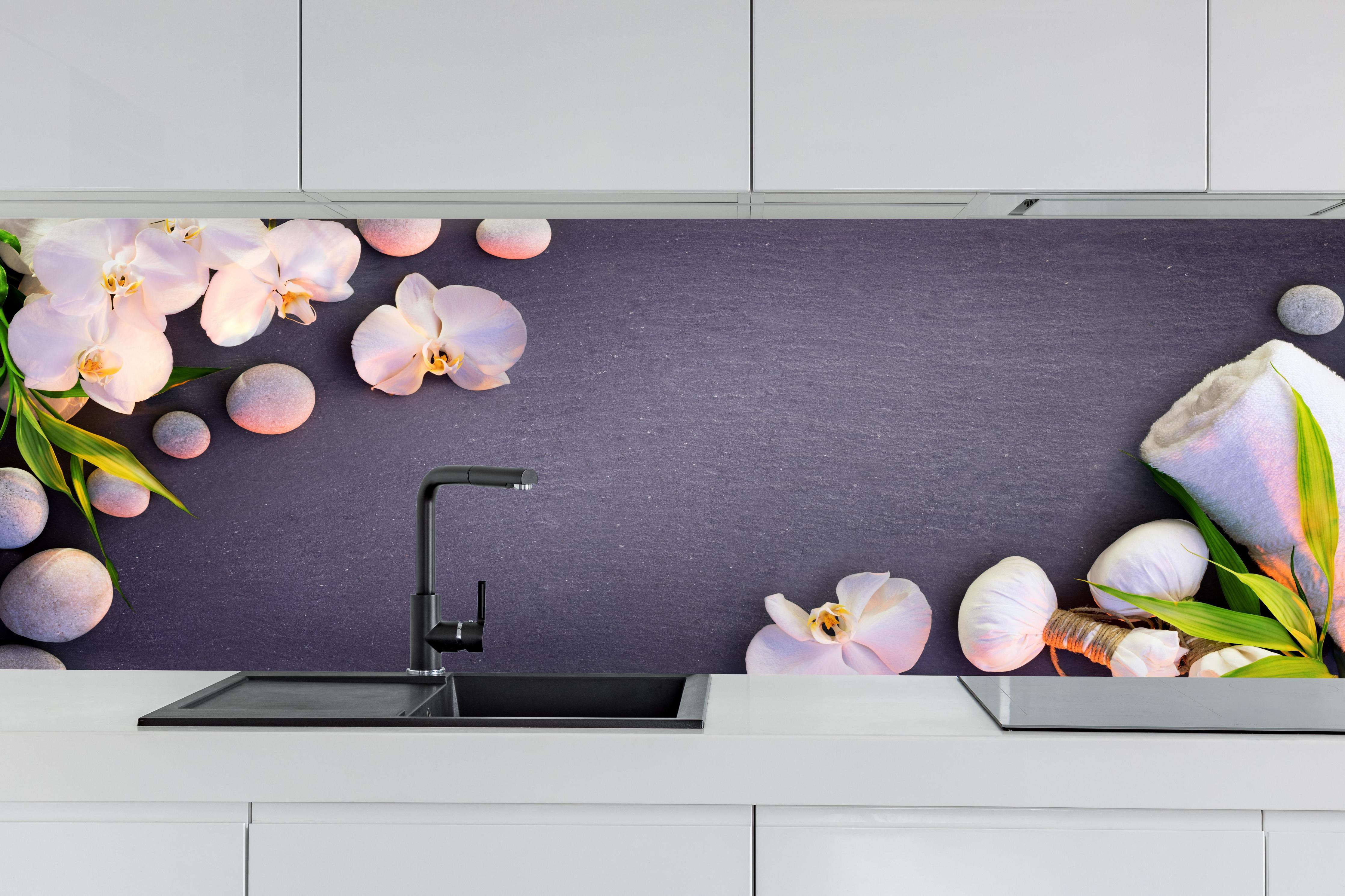 Küche - Weiß-Rosa Orchideen auf Schiefer hinter weißen Hochglanz-Küchenregalen und schwarzem Wasserhahn