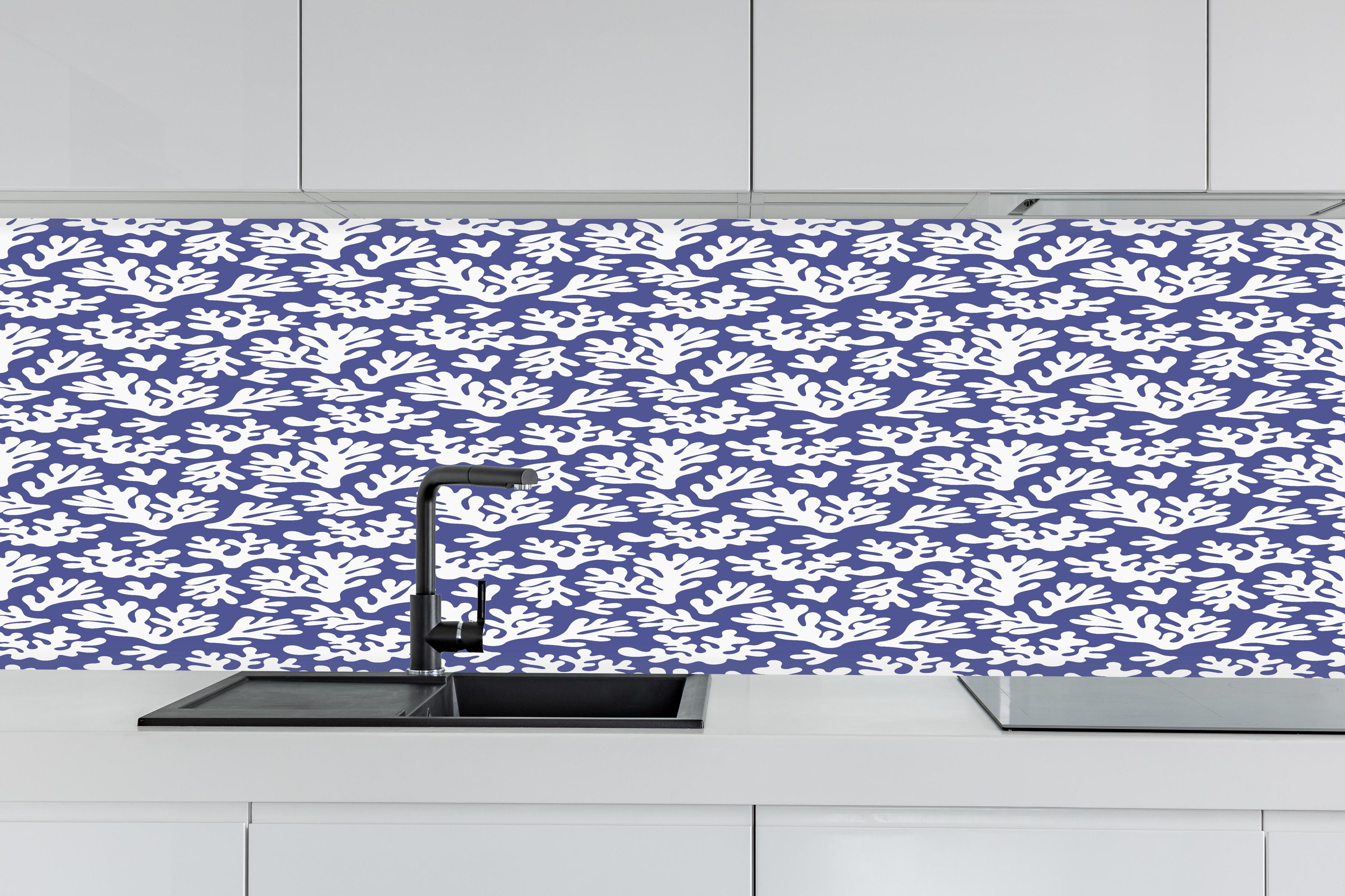 Küche - Weiße Korallen auf Blau hinter weißen Hochglanz-Küchenregalen und schwarzem Wasserhahn