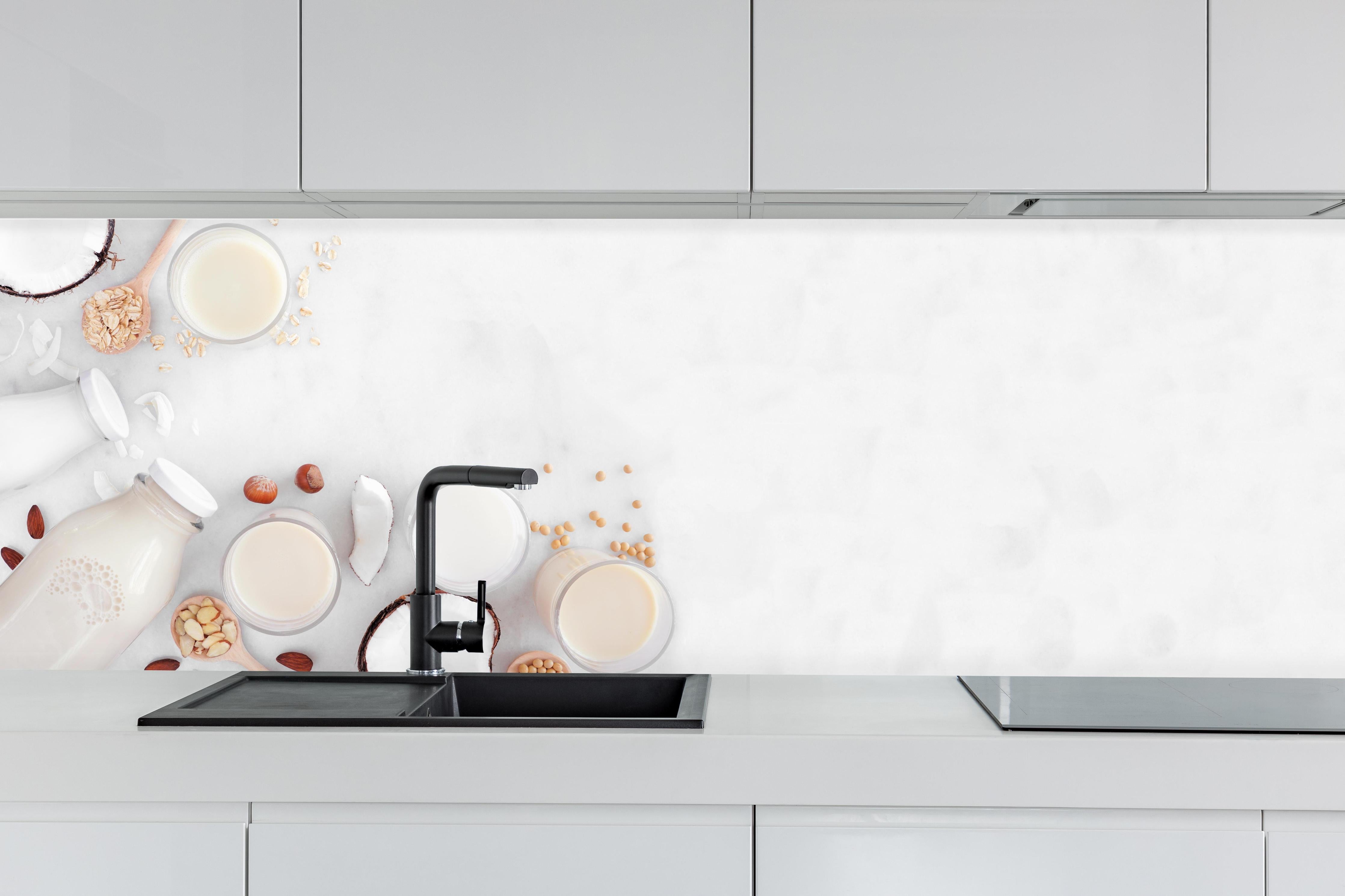 Küche - Weißes Pflanzenmilch-Stillleben hinter weißen Hochglanz-Küchenregalen und schwarzem Wasserhahn